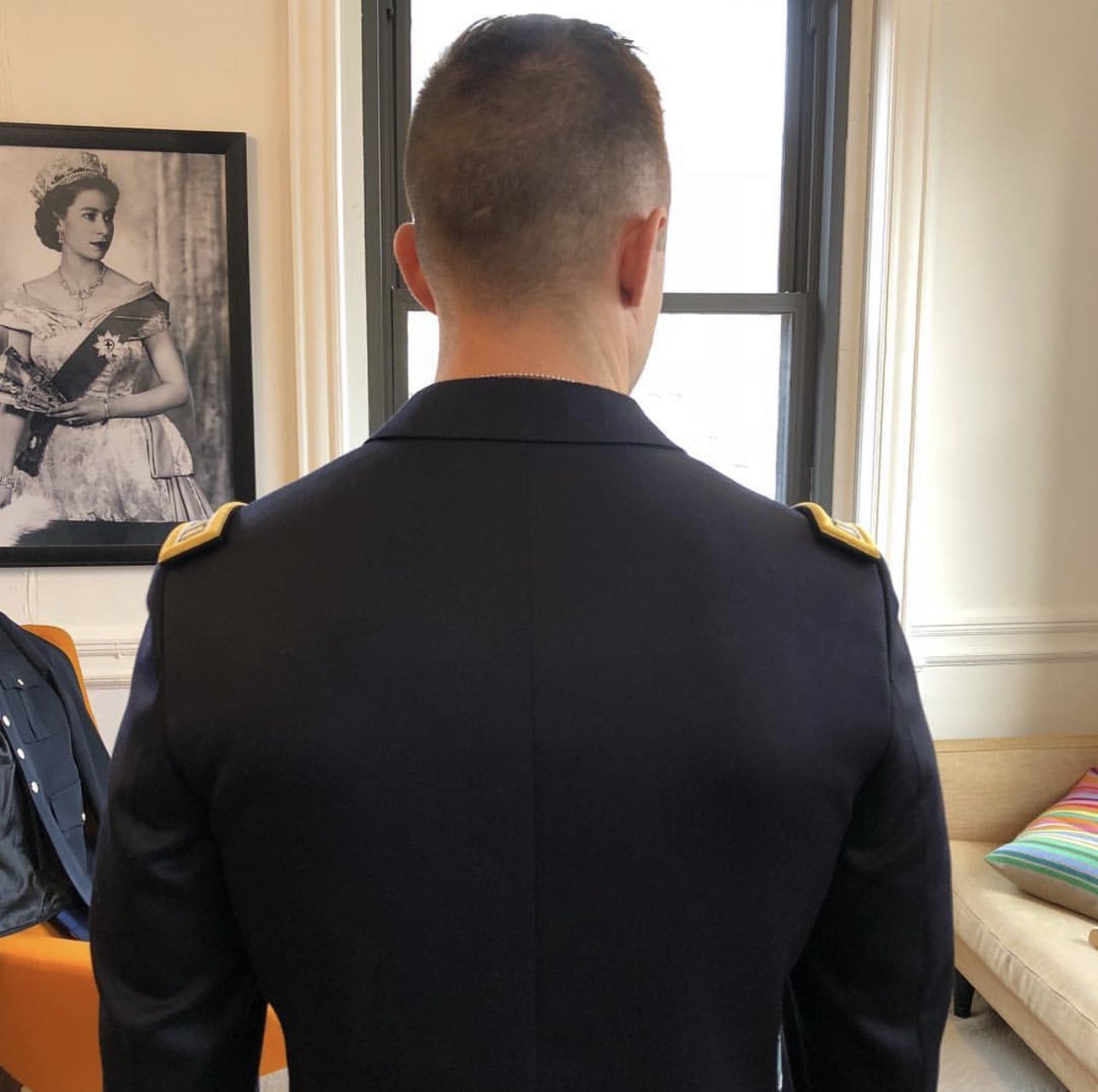 Being fitted for a bespoke military jacket: the view from the back
