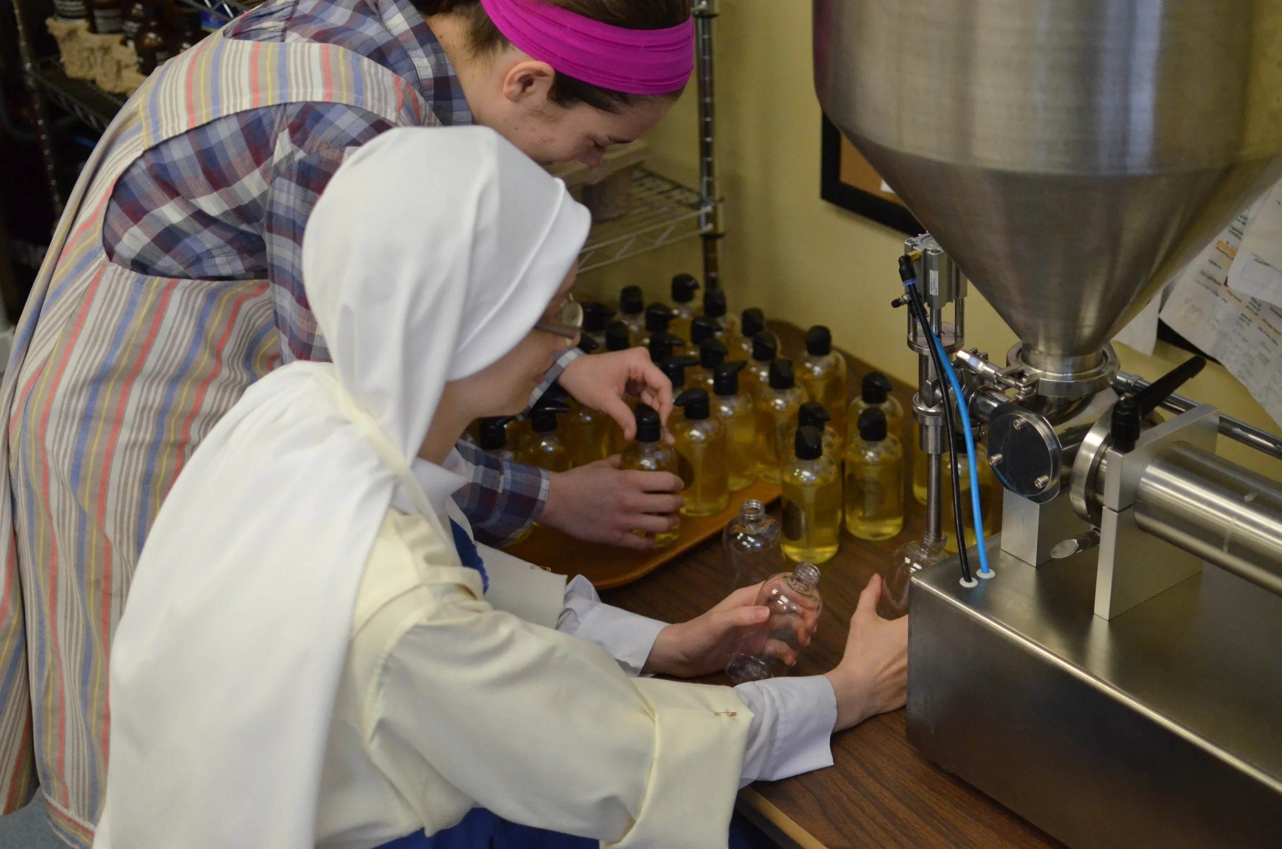 Our aspirant, Marie, helps Sr. Maria Johanna fill and cap liquid soap.