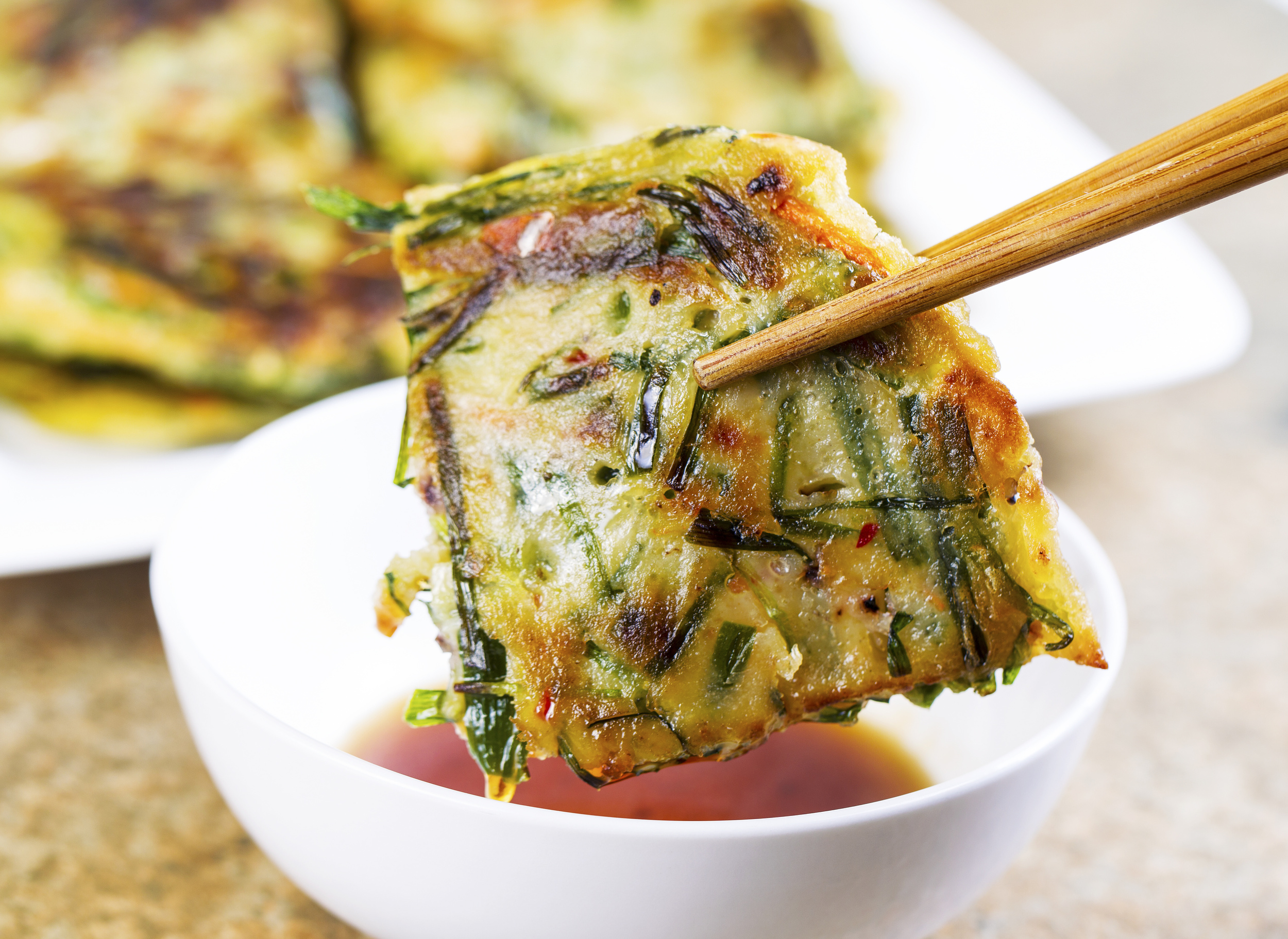 MINI GREEN ONION PANCAKE Cook's, Submitted by: Chin Yen Wang 2 Cups of All Purpose Flour 1 Cup of water 2 stalks of Green Onion Some Salt Vegetable Oil Mix flour with water to form a dough. Cover the dough with a damp towel, let the dough rest for more than an hour. Cut green onion to half an inch size Divide the dough into 4 portions. Work with one dough at a time. Flatten the dough with a rolling pin to about 9 inch in diameter. (Remember to sprinkle flour to prevent the dough from sticking onto the table) Continue to stretch the dough with your fist until the dough is paper thin. (very much like stretching a pizza dough, this step requires some skill) Brush the thin sheet with oil, sprinkle salt and green onion. Roll the dough sheet into a log shape, and cut the log into an inch thickness. Flatten each filled dough with your palm, and pan fried on a skillet at medium heat until golden brown on each side.