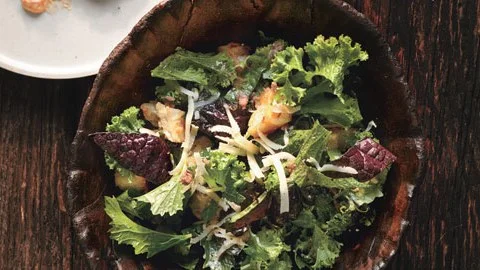 Photograph by Gentl Hyers Serves 6 Ingredients 5 anchovy fillets, finely chopped 3 garlic cloves, pressed 1/2 cup extra-virgin olive oil 3 cups 3/4-inch cubes crustless country bread 1 cup (packed) coarsely grated Gruyère cheese (about 4 ounces), divided Nonstick vegetable oil spray 1 bunch mustard greens (about 12 ounces), center rib and stem cut from each leaf, leaves cut crosswise into 1/2-inch-wide strips 5 teaspoons (or more) fresh lemon juice Preparation Preheat oven to 375°F. Combine anchovies and garlic in small bowl. Gradually whisk in oil. Place bread cubes in medium bowl. Drizzle 2 tablespoons anchovy oil over, tossing to coat. Sprinkle bread with salt, pepper, and half of cheese; toss to coat. Spray rimmed baking sheet with nonstick spray. Scatter bread on sheet. Bake croutons until crisp and golden, stirring occasionally, about 20 minutes. Set aside. Measure 8 cups (loosely packed) mustard greens and place in large bowl (reserve any remaining greens for another use). Add croutons and remaining cheese to bowl. Whisk 5 teaspoons lemon juice into remaining anchovy oil; season dressing with salt, pepper, and more lemon juice, if desired. Add dressing to salad; toss to coat.