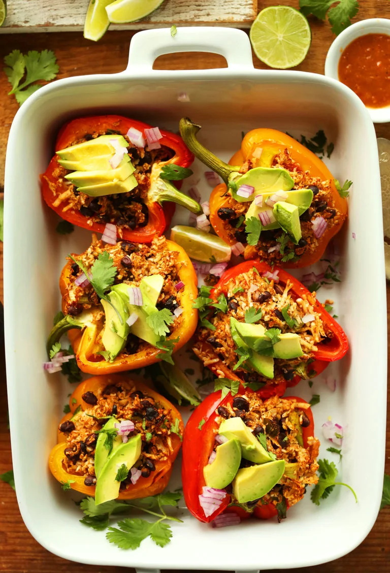Serves: 4 Ingredients CAULIFLOWER RICE 1 head cauliflower, grated into ‘rice’ ( see method here ) 1 Tbsp (15 ml) olive or grape seed oil optional: 3 cloves garlic, minced 1 cup (160 g) diced red, white, yellow, or green onion (I recommend red) Pinch each sea salt and black pepper PEPPERS 4 large red, yellow, or orange bell peppers, halved, seeds removed 1 15-ounce (425 g) can black or pinto beans, rinsed and drained (if unsalted, add additional salt to taste) 2/3 cup (~170 g) salsa, plus more for serving (very flavorful salsa, like Trader Joe’s Chunky Salsa) 2 tsp cumin powder, plus more to taste 2 tsp chili powder, plus more to taste 2-3 Tbsp (30-45 ml) lime juice 1/4 tsp each sea salt and black pepper, plus more to taste TOPPINGS optional 1 ripe avocado, sliced Fresh lime juice Hot sauce Cilantro, chopped Diced red onion Creamy Cilantro Dressing Chipotle Red Salsa (or your favorite salsa) Instructions Preheat oven to 375 degrees F (190 C) and set out a 9x13-inch baking dish or rimmed baking sheet. Also brush halved peppers with a neutral, high heat oil, such as grape seed, avocado or refined coconut. Set aside. Prepare cauliflower rice by following these instructions . Then heat a large rimmed skillet over medium heat. Once hot, add oil, garlic (optional), onion, salt and pepper. Sauté for 1 minute, stirring frequently. Then add cauliflower ‘rice’ and stir to coat. Place the lid on to steam the rice for about 1 minute. Then remove from heat and transfer the mixture to a large mixing bowl. You aren't looking to completely cook the 'rice,' as it will continue cooking in the oven. Add remaining ingredients - black beans through salt and pepper - to the cauliflower rice and mix to thoroughly combine. Taste and adjust seasonings accordingly, adding salt, pepper, or more spices as desired. Generously stuff halved peppers with ~ 1/2 cup of the mixture until all peppers are full (you may have a little leftover filling, which can be added to salads or served on the side), then cover the dish with foil. Bake for 30 minutes covered. Then remove foil, increase heat to 400 degrees F (204 C), and bake for another 15-20 minutes or until peppers are soft and slightly golden brown. For softer peppers, bake 5-10 minutes more. Serve with desired toppings (listed above) or as is. I recommend avocado, lime juice, hot sauce, and cilantro. Best when fresh, though leftovers keep covered in the refrigerator for 2-3 days. Reheat in a 350 degree F (176 C) oven until warmed through - about 20 minutes. See notes for instructions on making ahead of time.