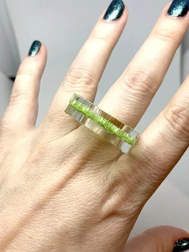 A modern ring made of layered plexiglass with a laser-engraved digital pattern