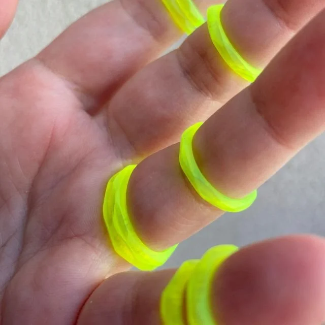 Translucent neon yellow plexiglass rings from the Uneven collection — hand-crafted, upcycled jewelry with a contemporary sculptural aesthetic.