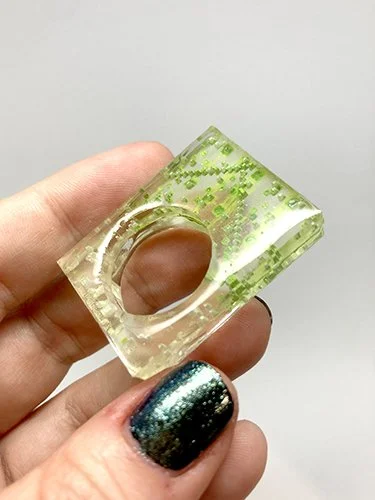 A modern ring made of layered plexiglass with a laser-engraved digital pattern