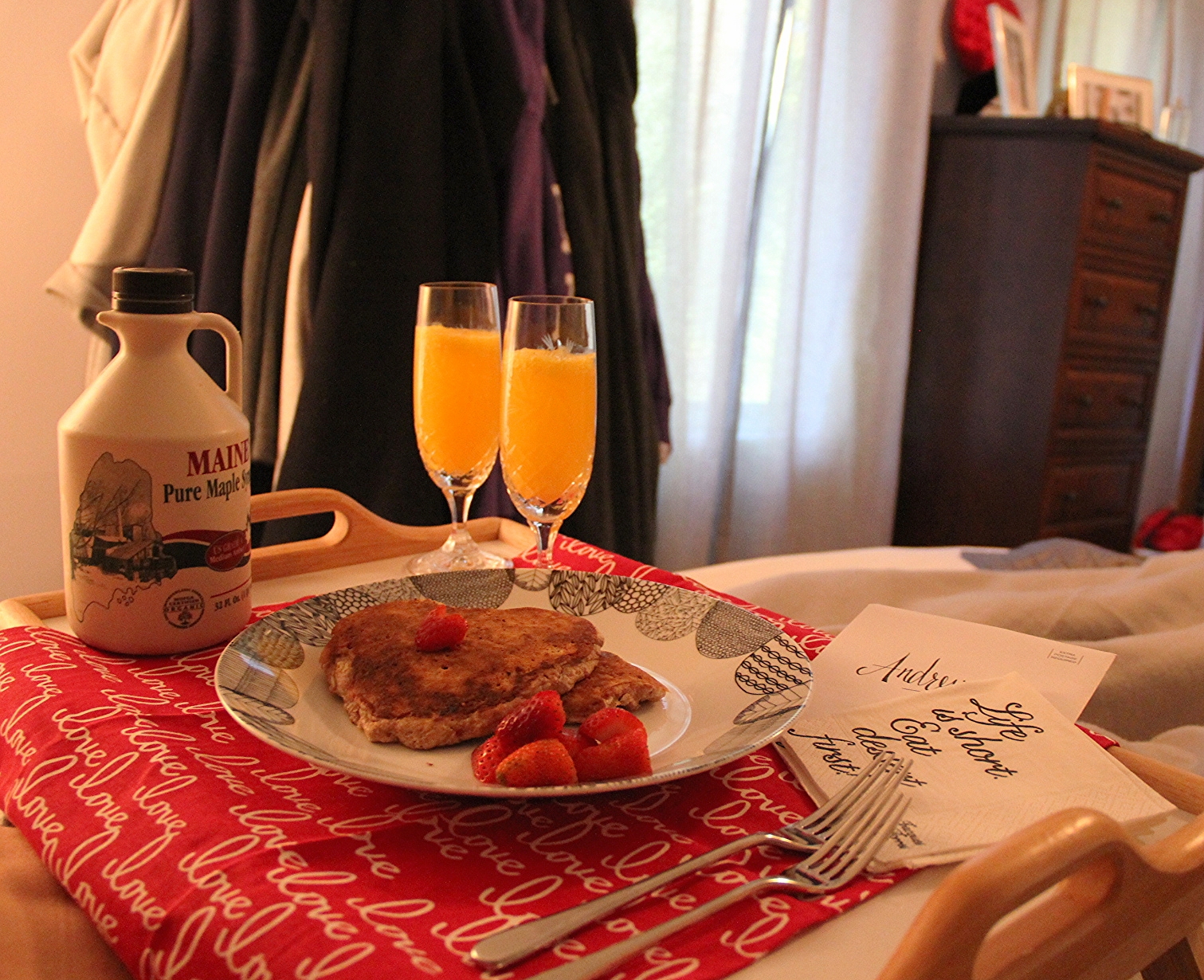 Pancakes in bed. Added some flare to the stand by adding a valentines day love cloth napkin below, fun paper napkins and cutting a couple of strawberries into hearts