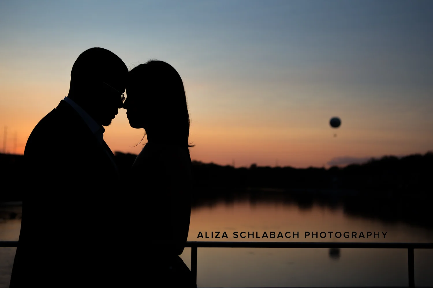 Silhouette of a couple at dusk in front of Philadelphia's boat house row