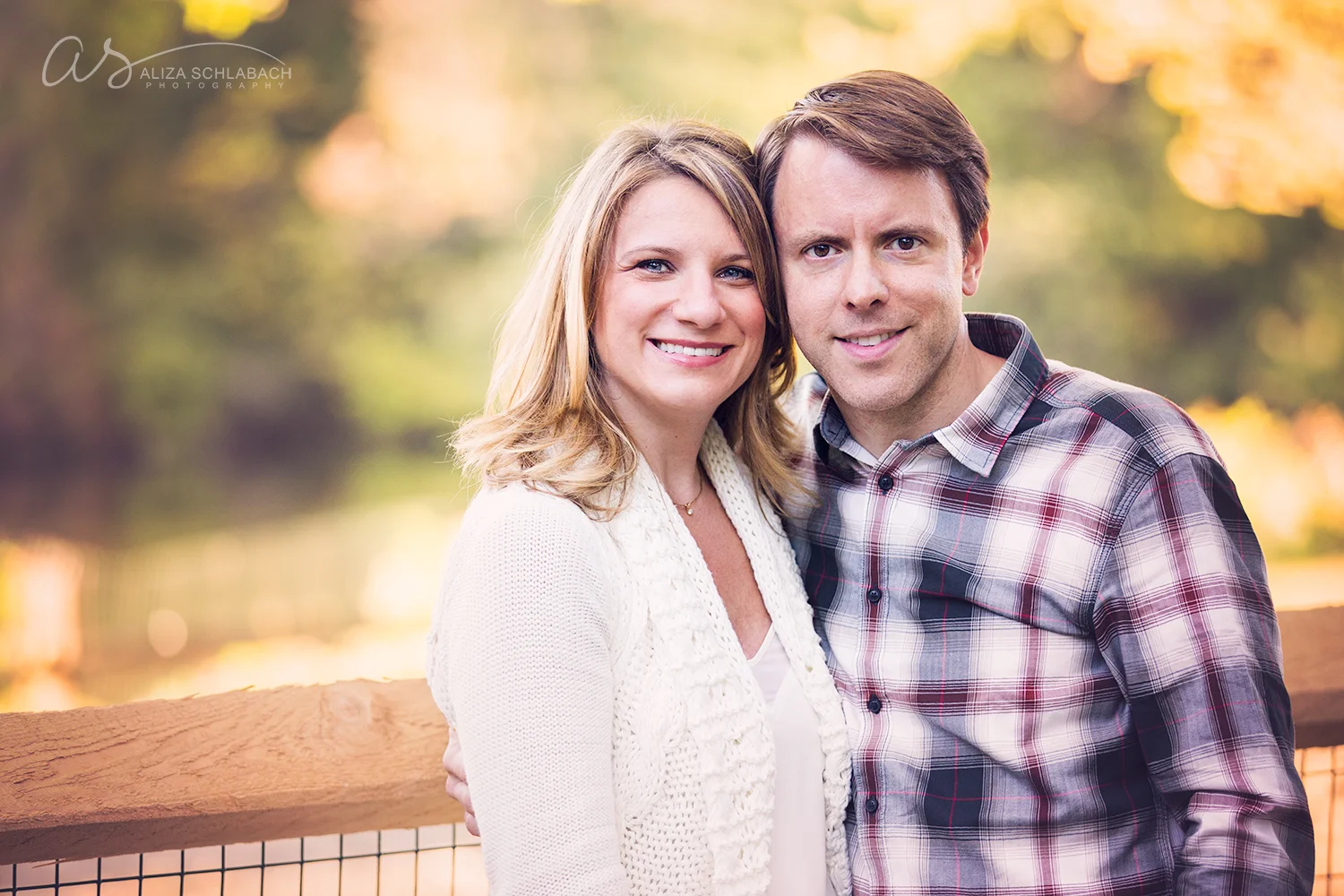 Photo of a man in a plaid shirt and a woman in a white sweater outside during golden hour