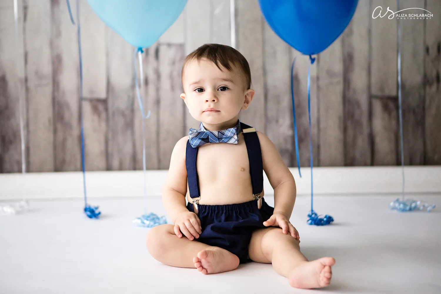 Photo of a baby in a bowtie during his cake smash photography session