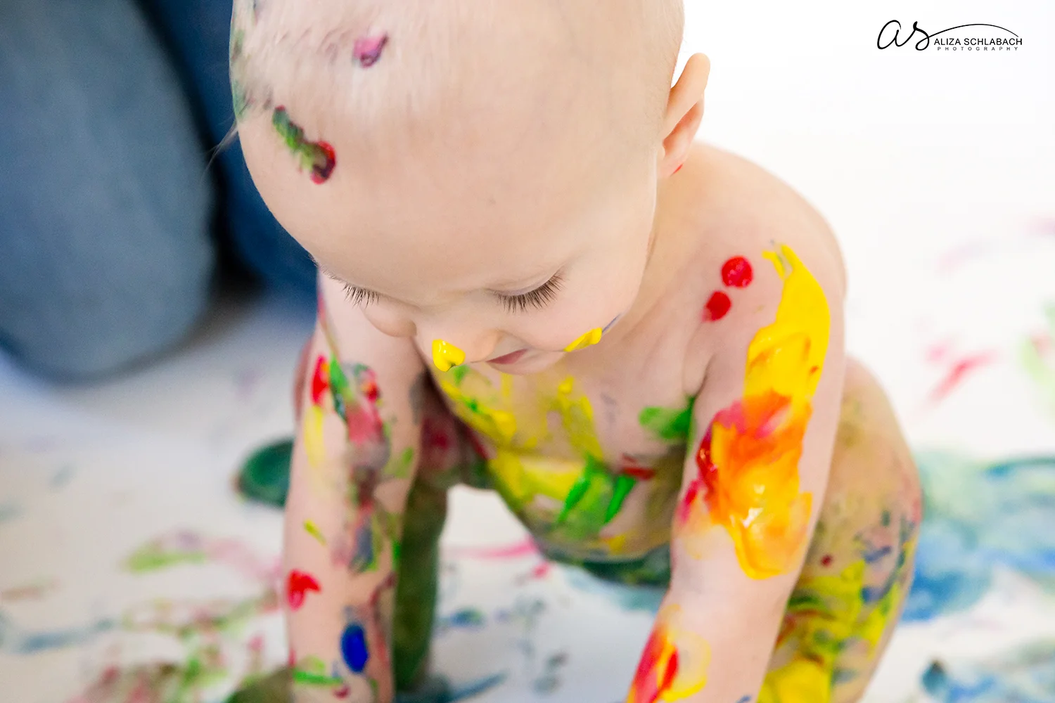 Close up photo of one year old covered in fingerpaint