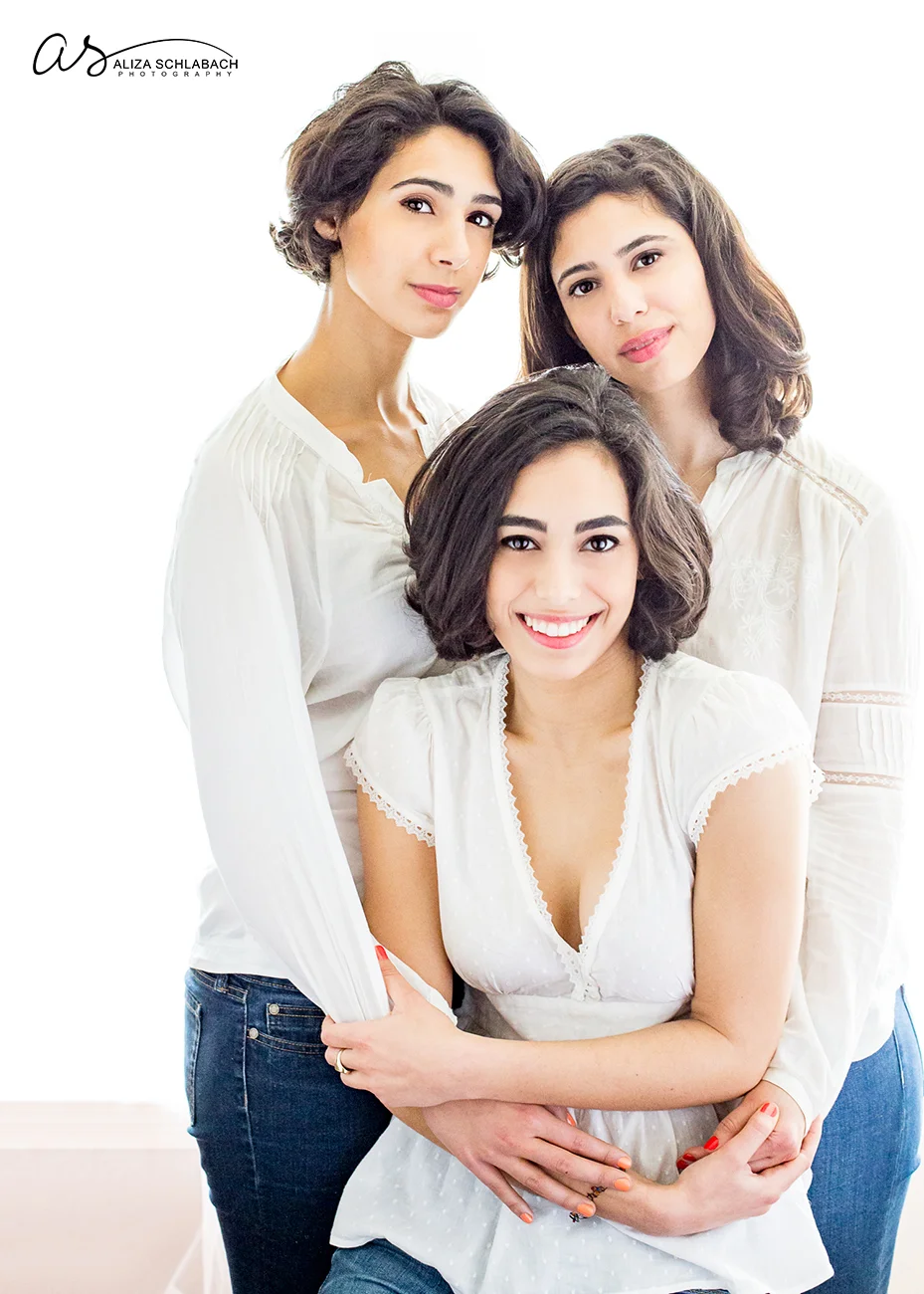 Backlit portrait of three young adult sisters