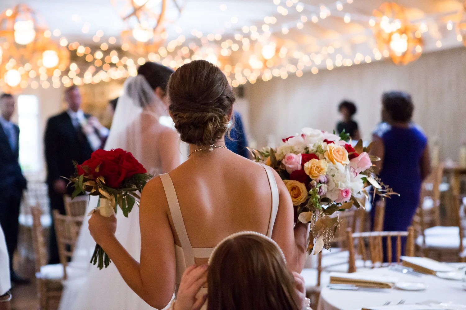 Photo of bride and maid of honor backs at wedding reception