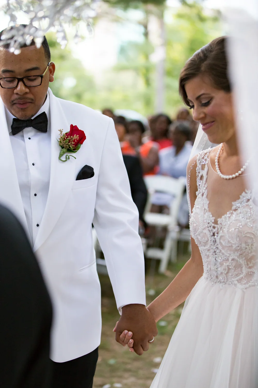 Bride and groom holding hands during outdoor wedding ceremony