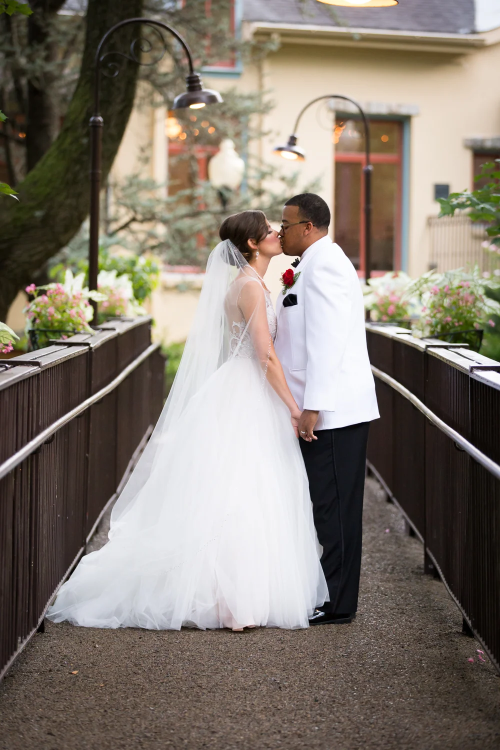 Portrait of bride and groom kissing on the bridge at The Pomme in Radnor