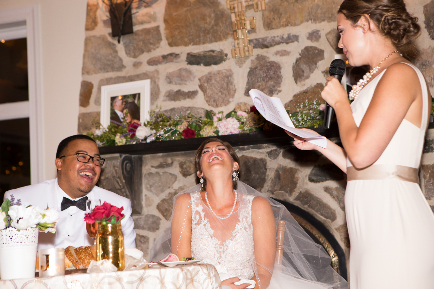 Picture of bride and groom laughing during maid of honor's speech