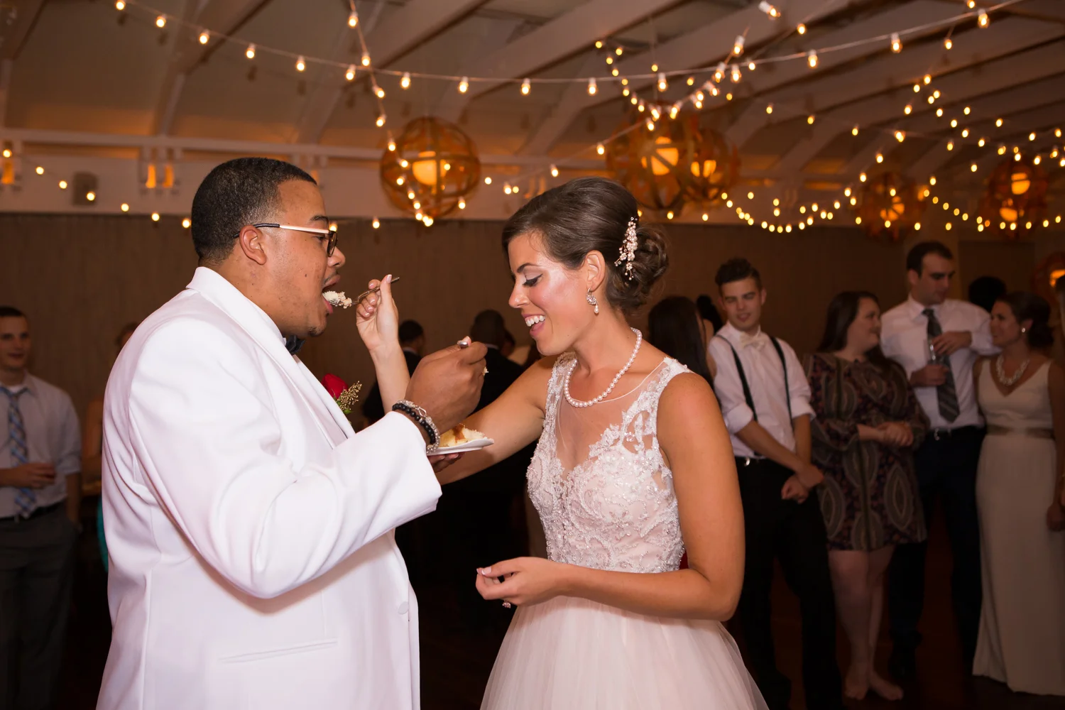 Photograph of bride and groom feeding each other wedding cake