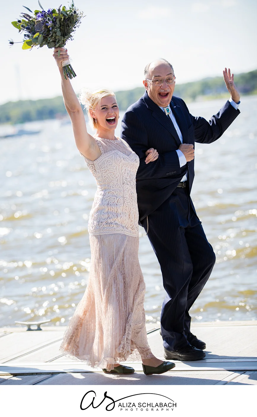 Photo of a bride and her father walking down a boat dock