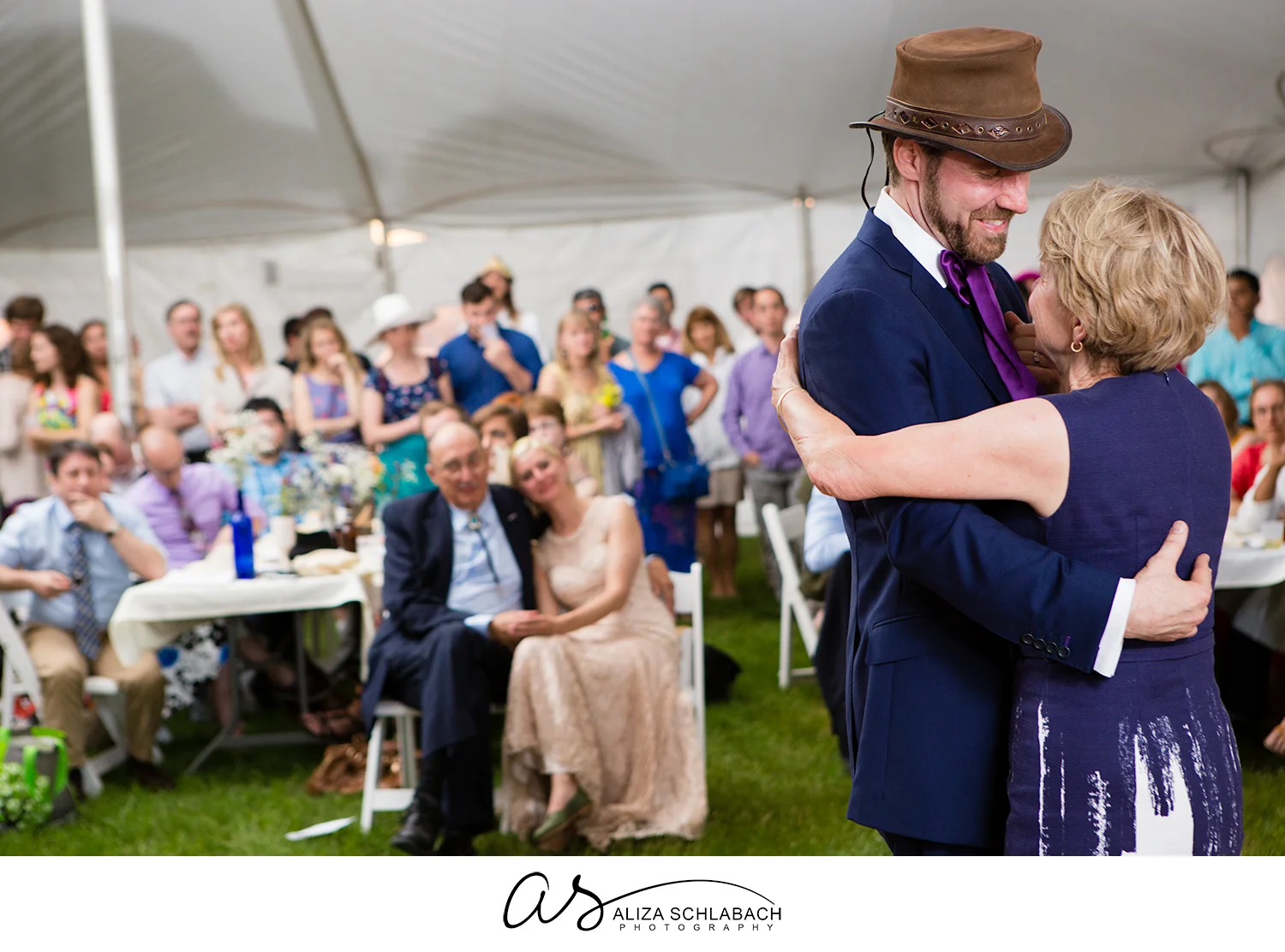Photo of groom dancing with his mother in a tent at his wedding