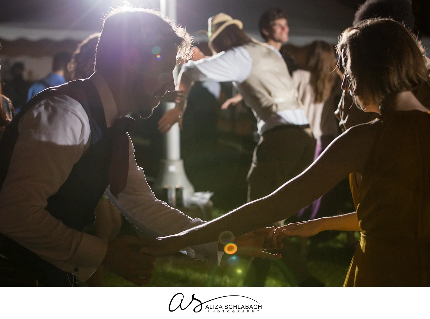 Image of groom and guest dancing during outdoor wedding reception