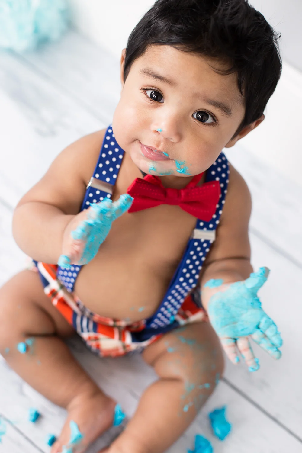 Boy looking up at camera during cake smash