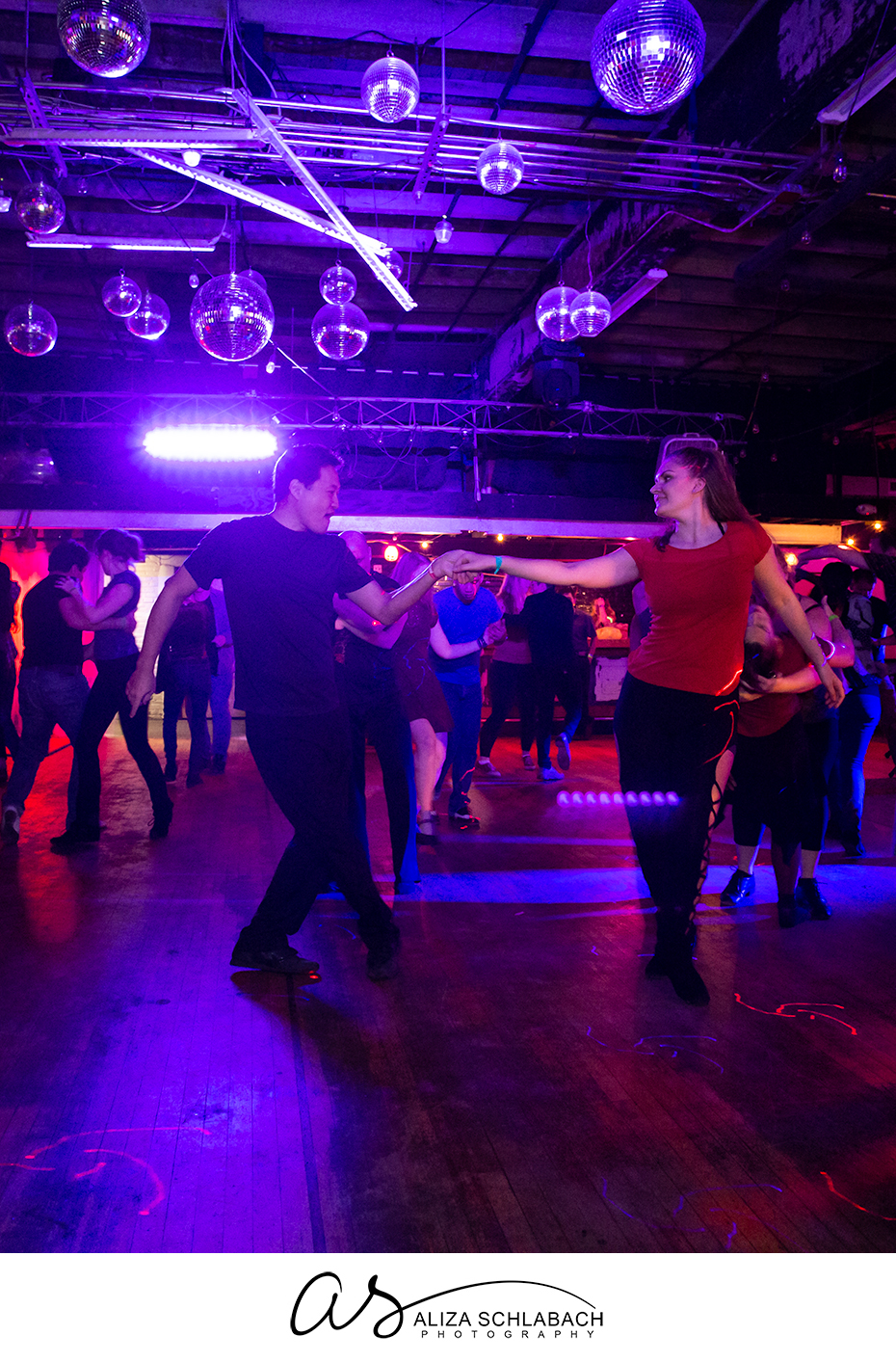 Photograph of partner dancing under disco balls