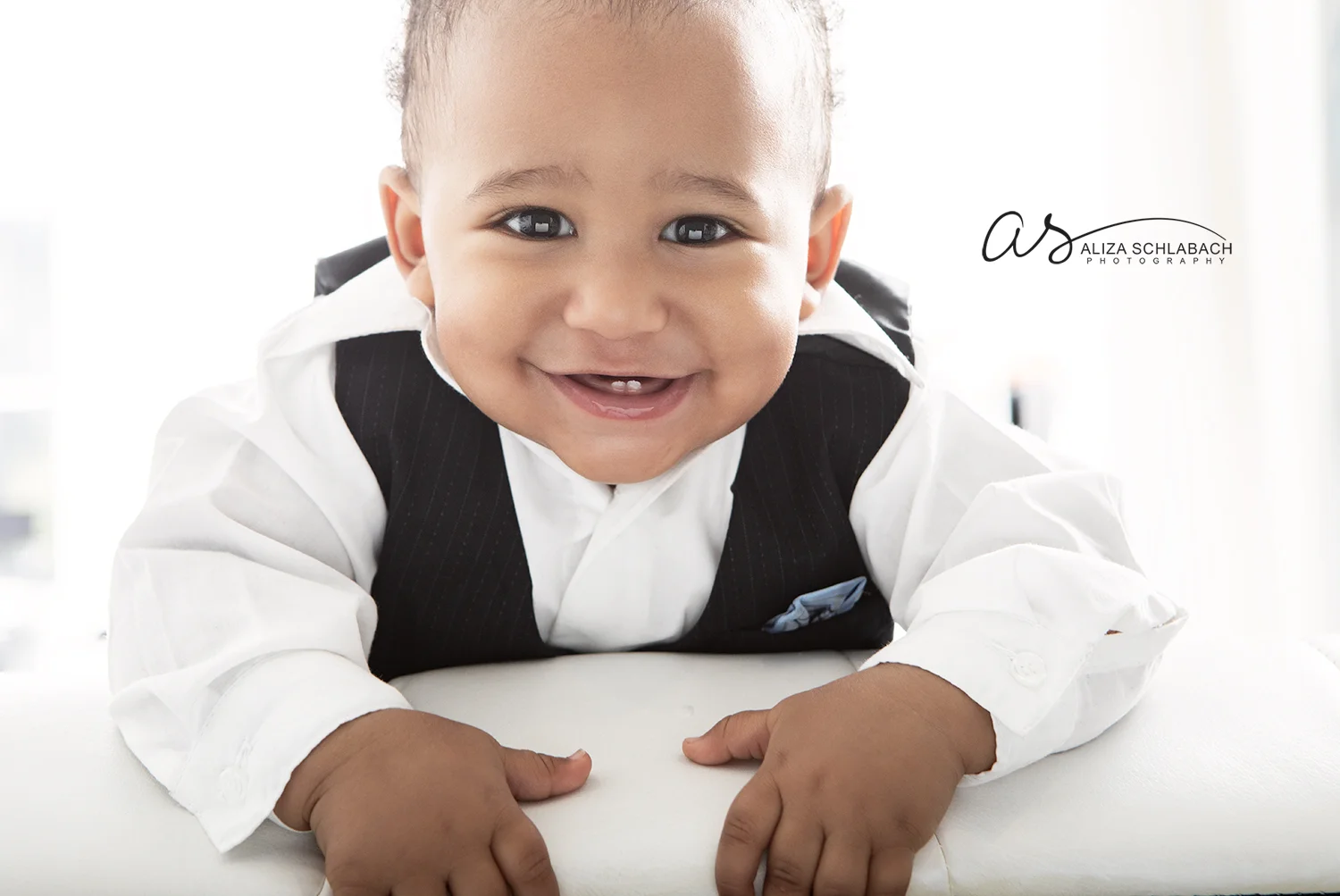 Photo of a backlit smiling baby with 2 teeth