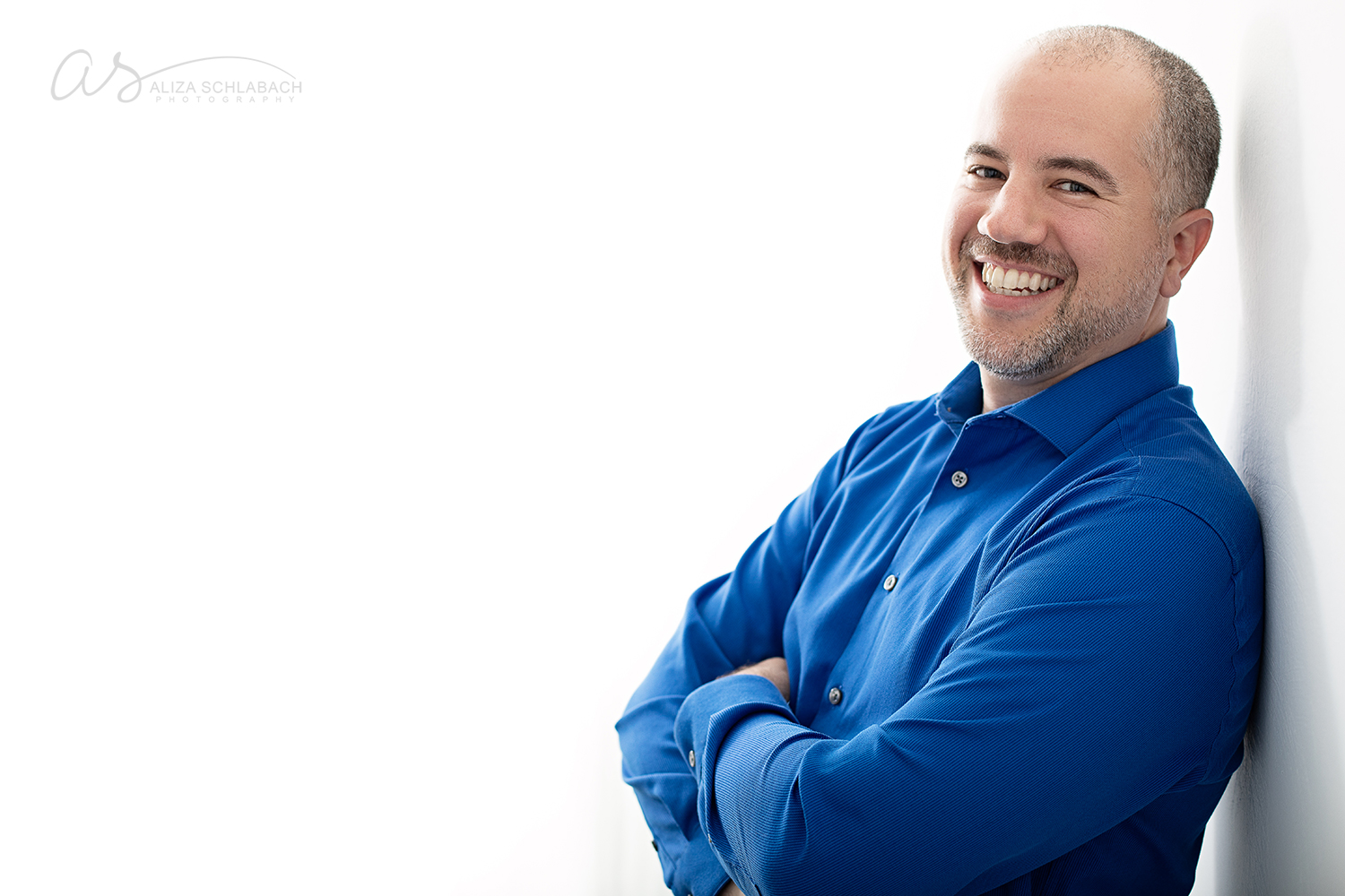 Backlit headshot of a 40 year old man in a blue button down shirt