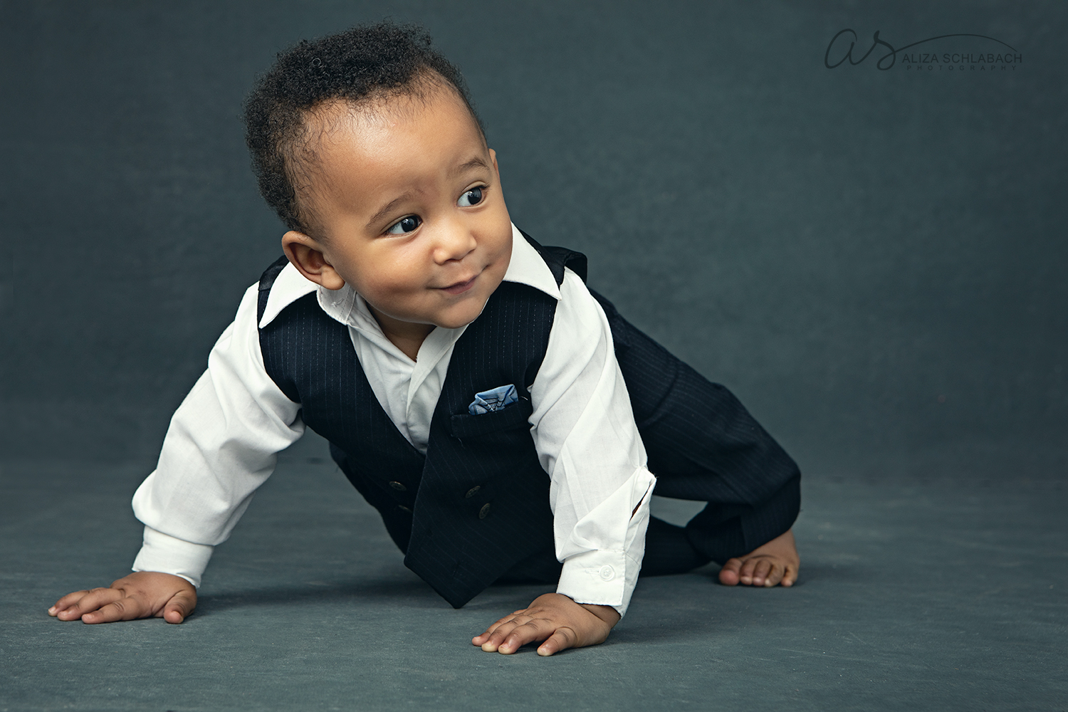 Portrait of a cute black baby crawling in a suit