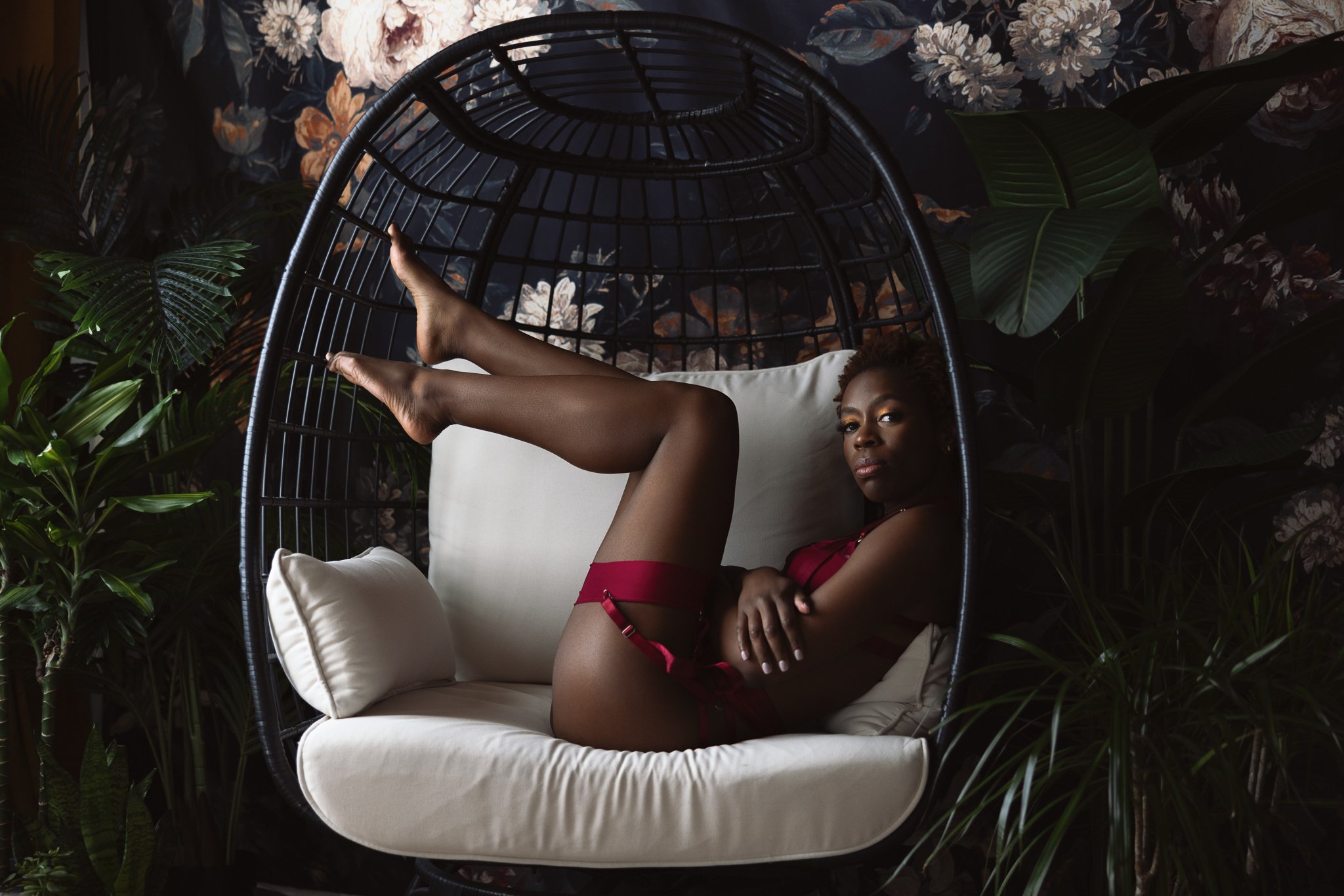 Moody boudoir photo of a pretty black woman in an egg chair