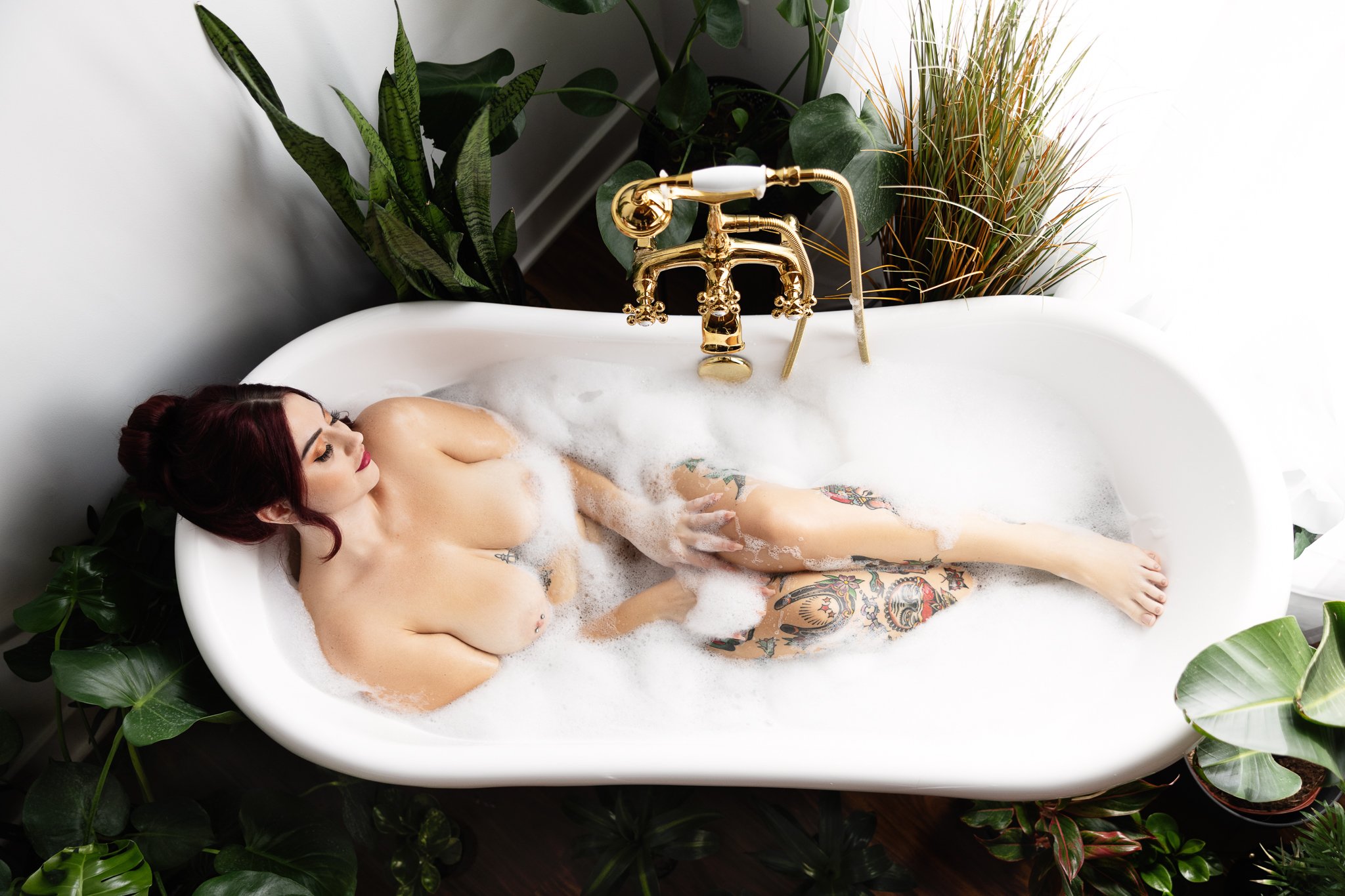 Photo of a beautiful tattooed woman in a bubble bath