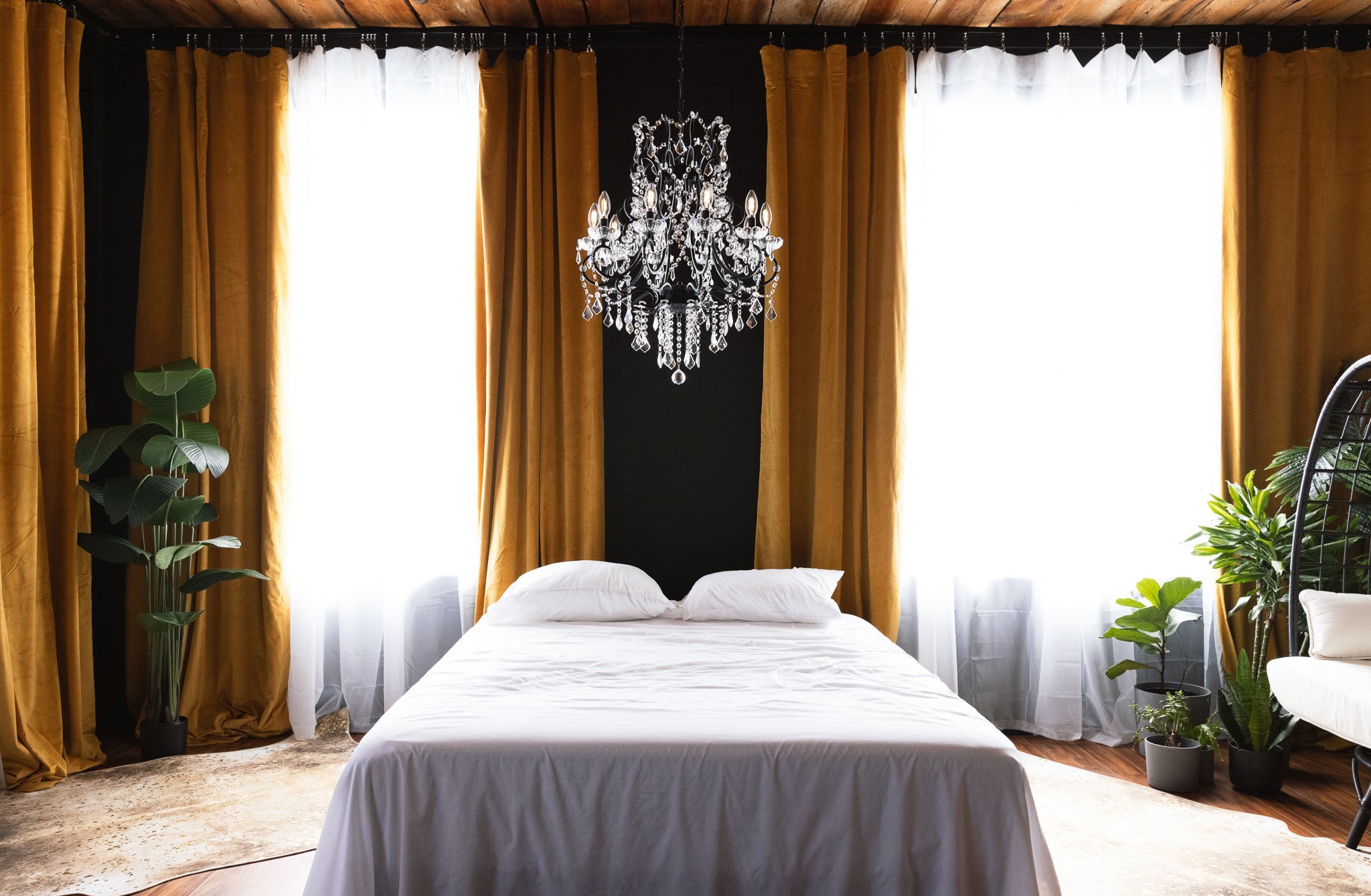 Photo of Aliza Schlabach Photography's luxury studio with bed and chandelier