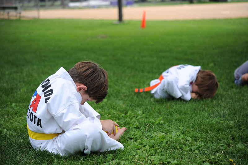 Harrison, her next door neighbor, practices his stretching... his personal challenge: to touch his nose to his toes!