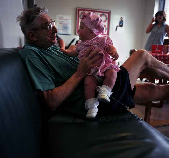John, a retired Lieutenant in the New York Fire Dept. holds his first granddaughter in the commons room on the 8th floor of Mt. Sinai Hospital.