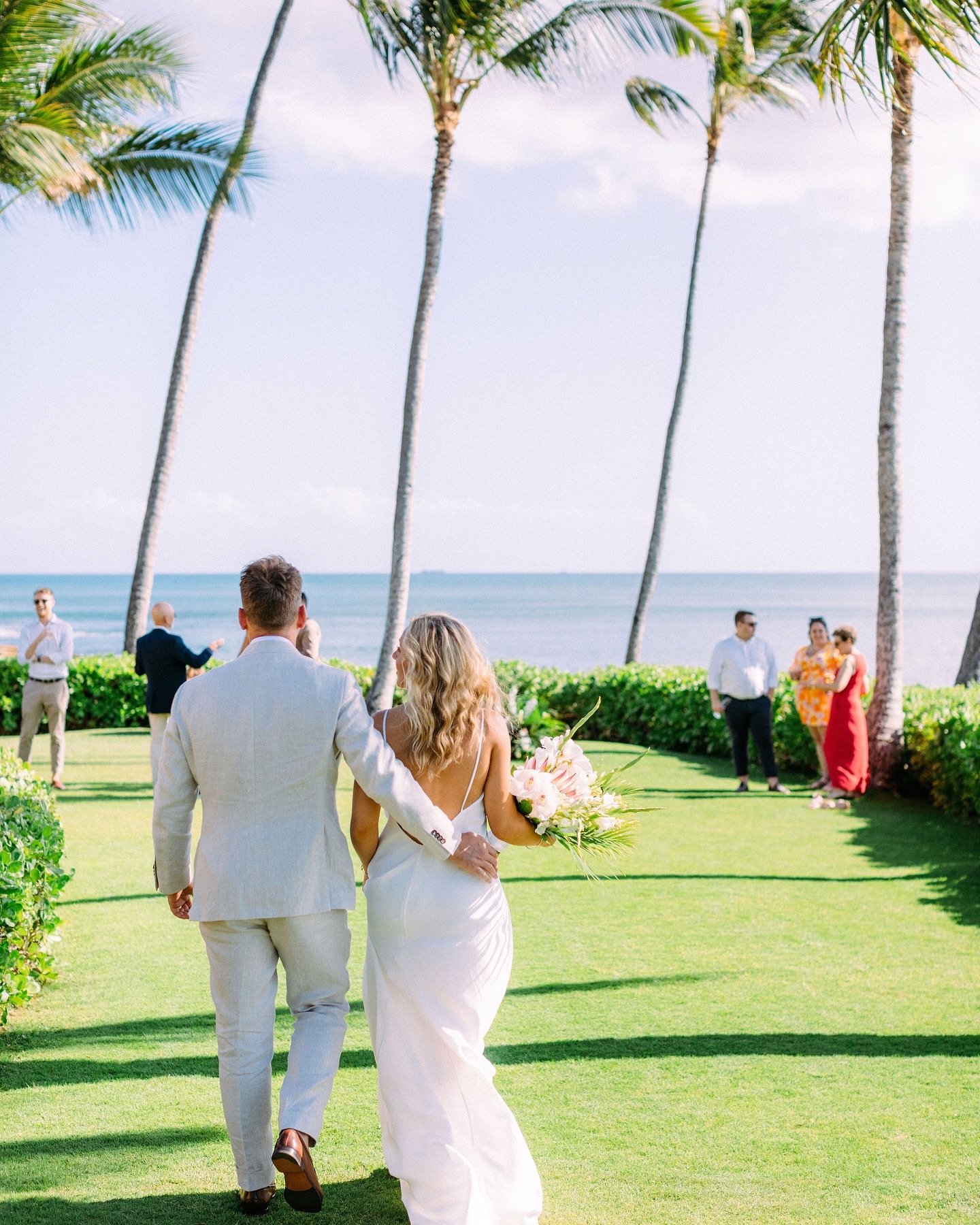 Ready to walk into life as a married couple 🤍🤍
.
Newlyweds @__jackieelizabeth @denmccallum 
Venue @paradisecoveluau 
Wedding Planning @whiteorchidwedding 
Floral Design @jadorefloralhawaii 
MUAH @revealhairandmakeup 
Wedding Dress @grace_loves_lace