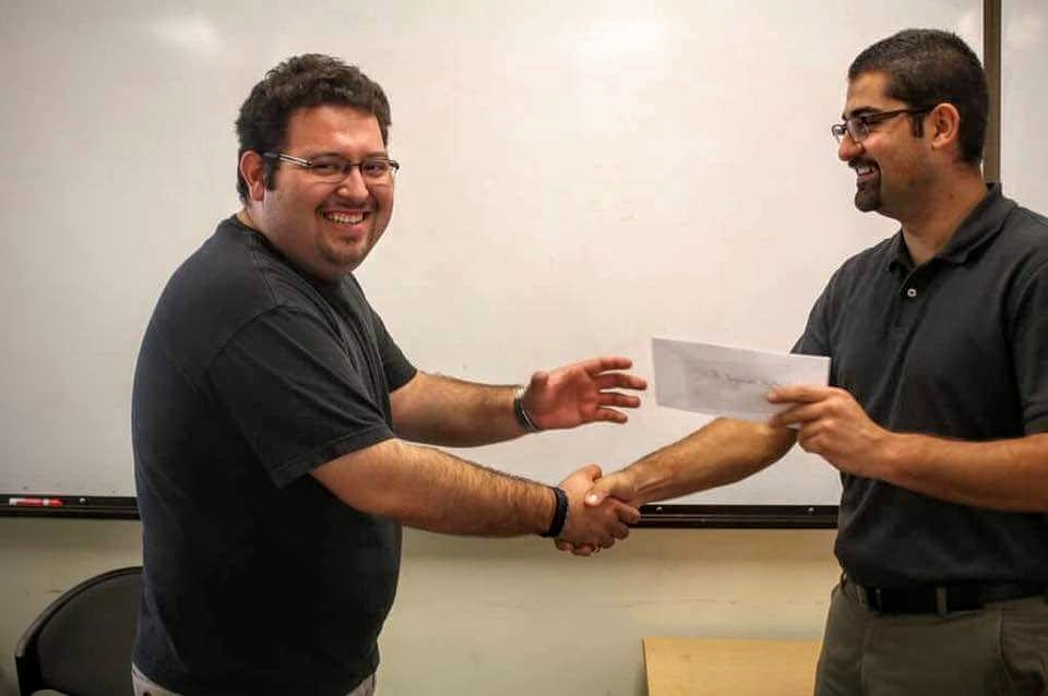 Juan Zepeda, one of the Four Ingenieros Founder, handing over the check to Miguel Lopez, SHPE Ingenium President, for the sponsorship of the Four Ingenieros Engineering Competition.
