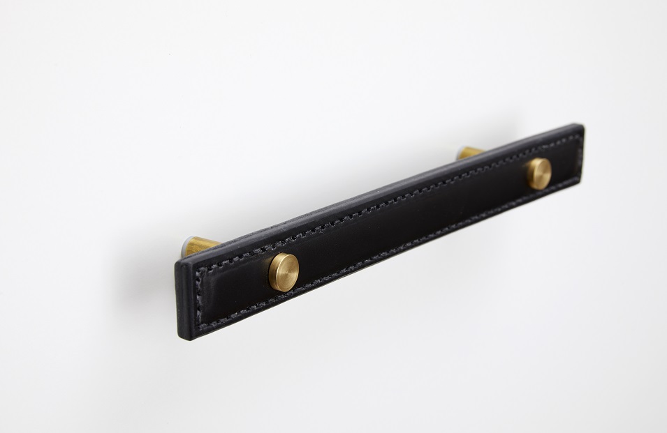 Side view of brass hardware on black leather handle