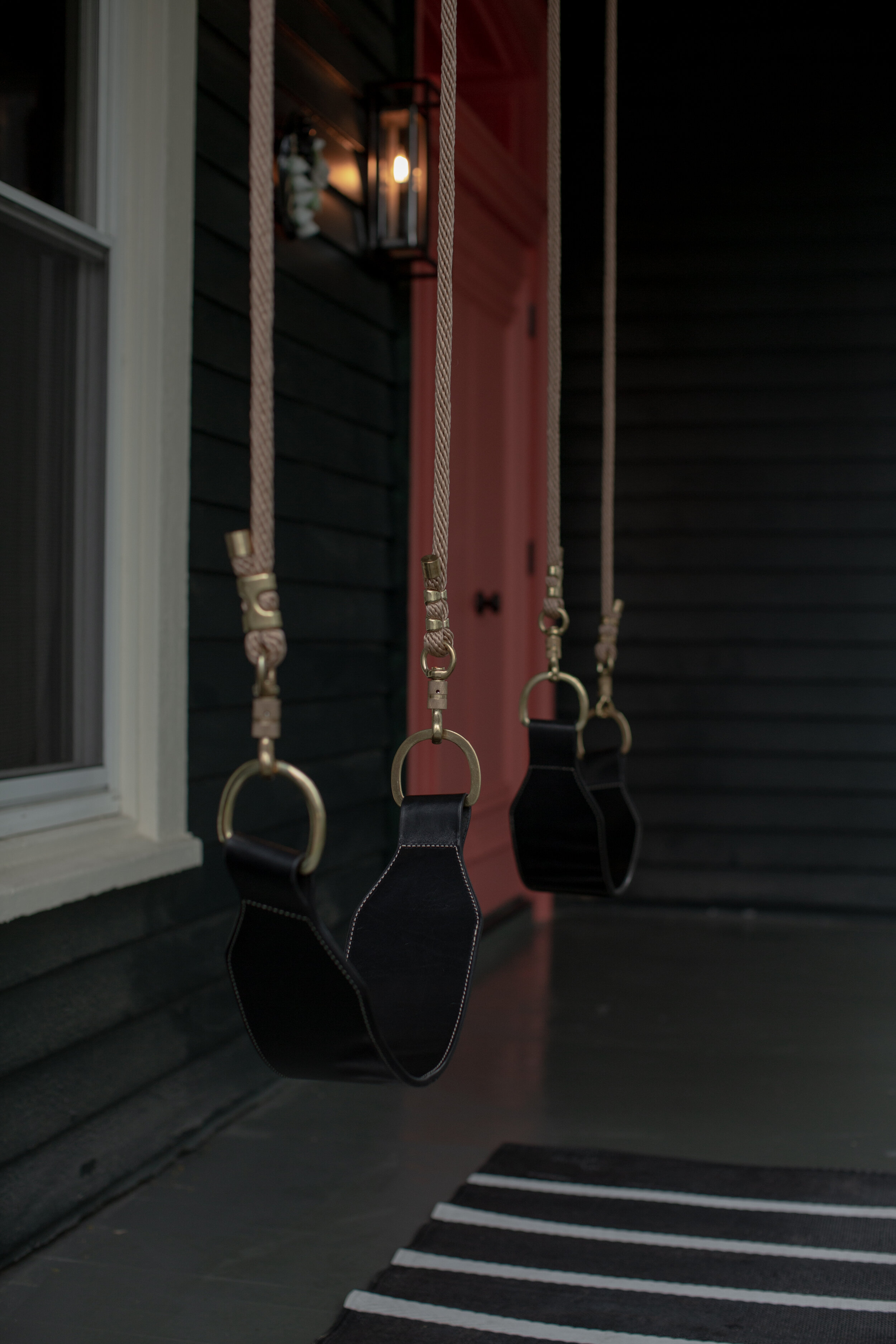 Two black leather swings shown on porch