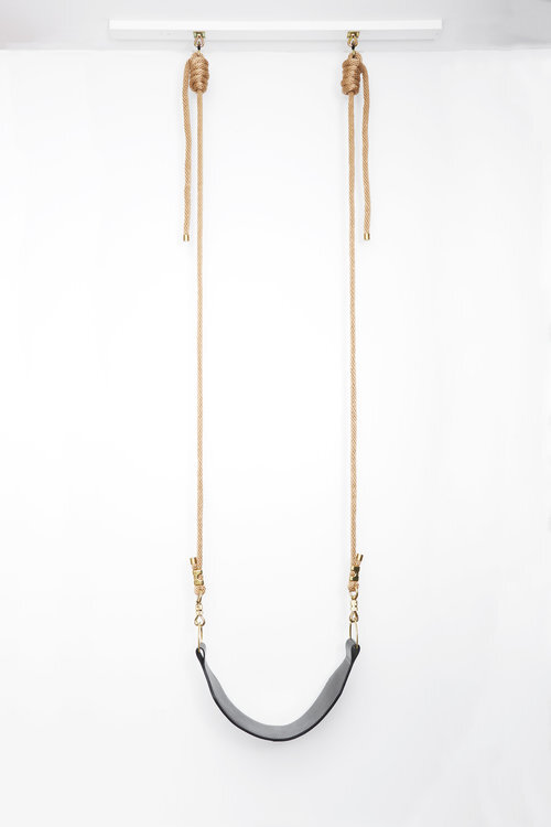Black leather swing against a white background