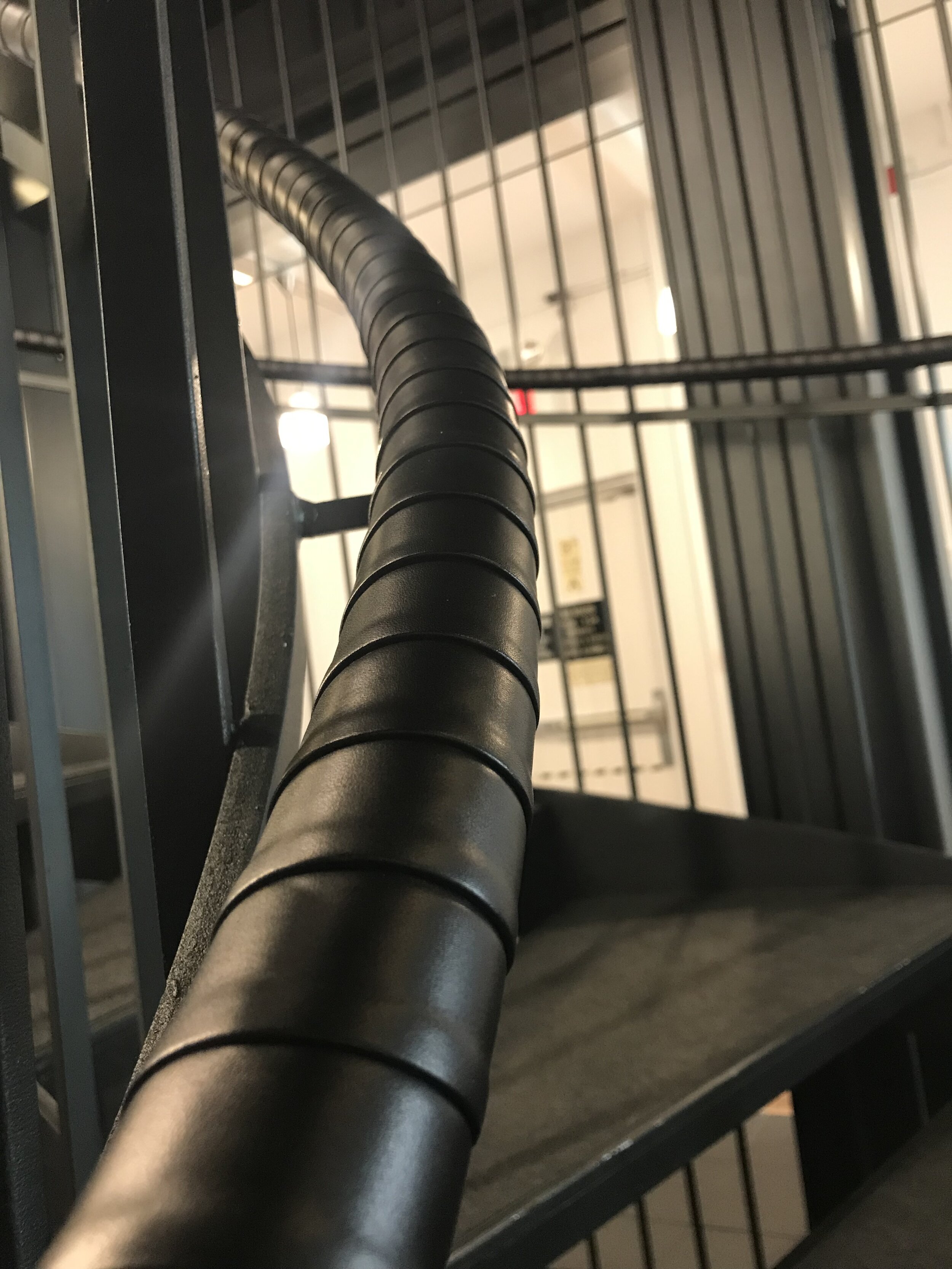 Close up of black leather wrapped handrail on spiraled staircase