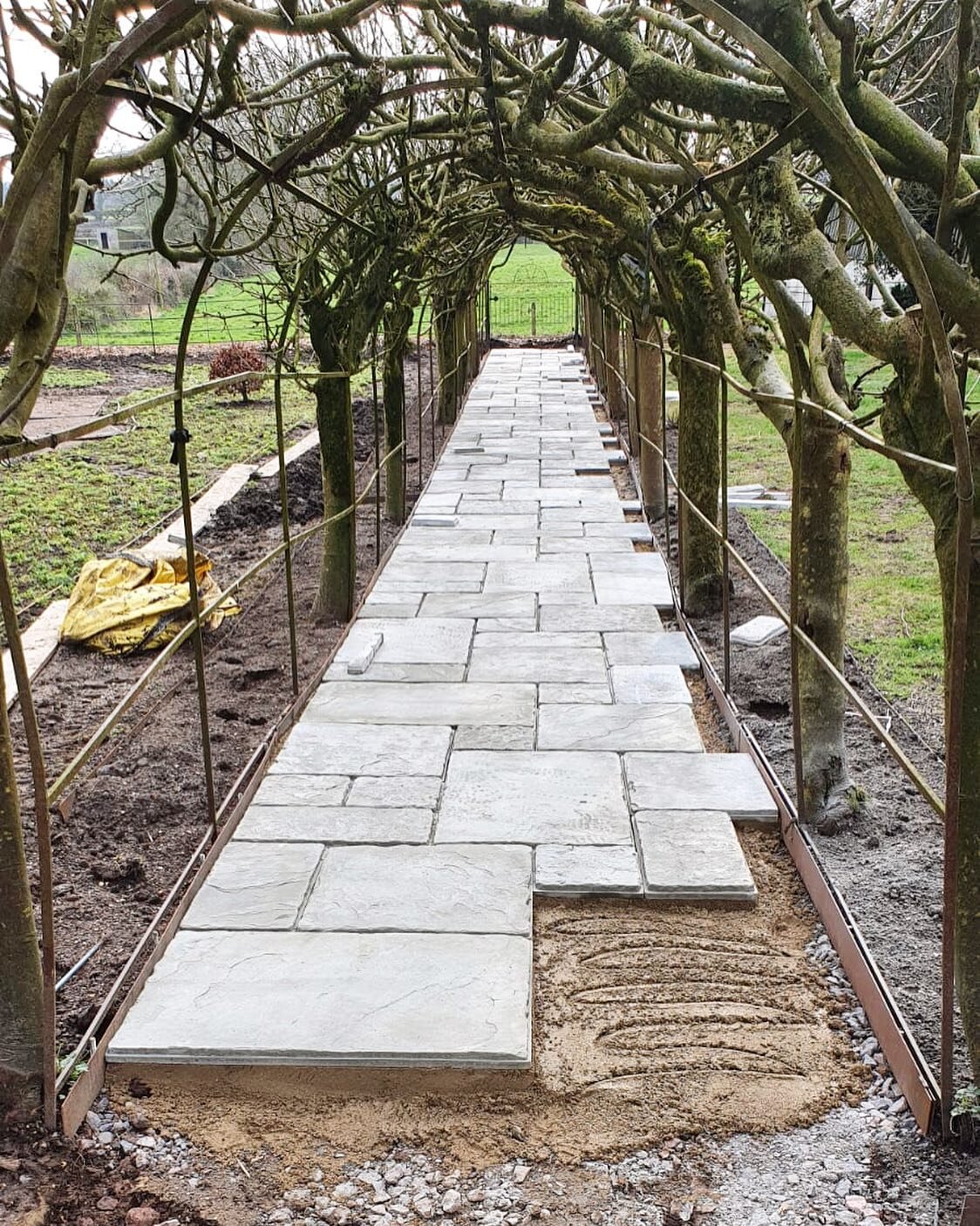 Exciting to see this project progressing now with the paving going down under the Laburnum arch.  Well done to the team at County Lawns &amp; Trees for a great job 👏 #gardendesign #landscaping #laburnumarch #teamwork #construction #wiltshire