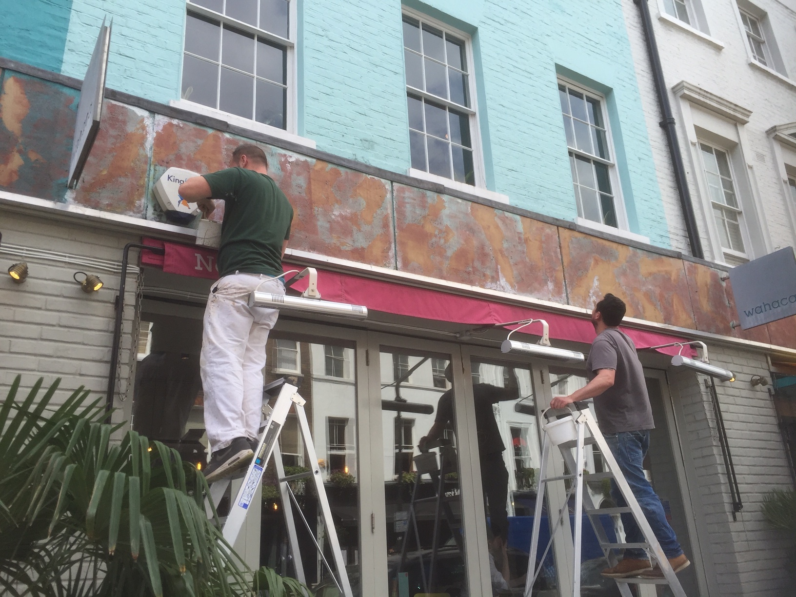 Getting to work on the Wahaca Restaurant sign, Charlotte Street in London.