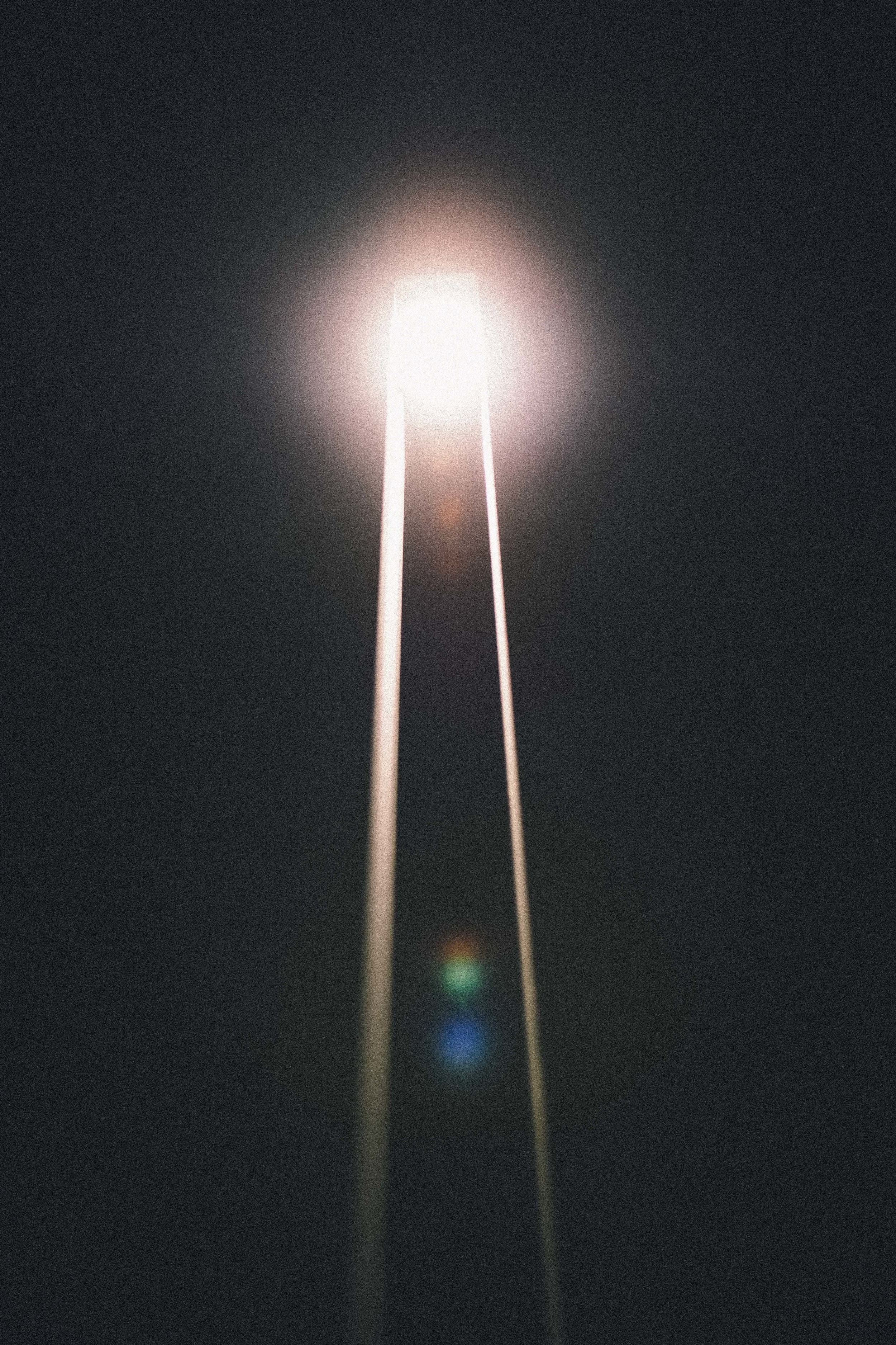 Blue, green, and red dots merge to become white light streaming down from the sky.