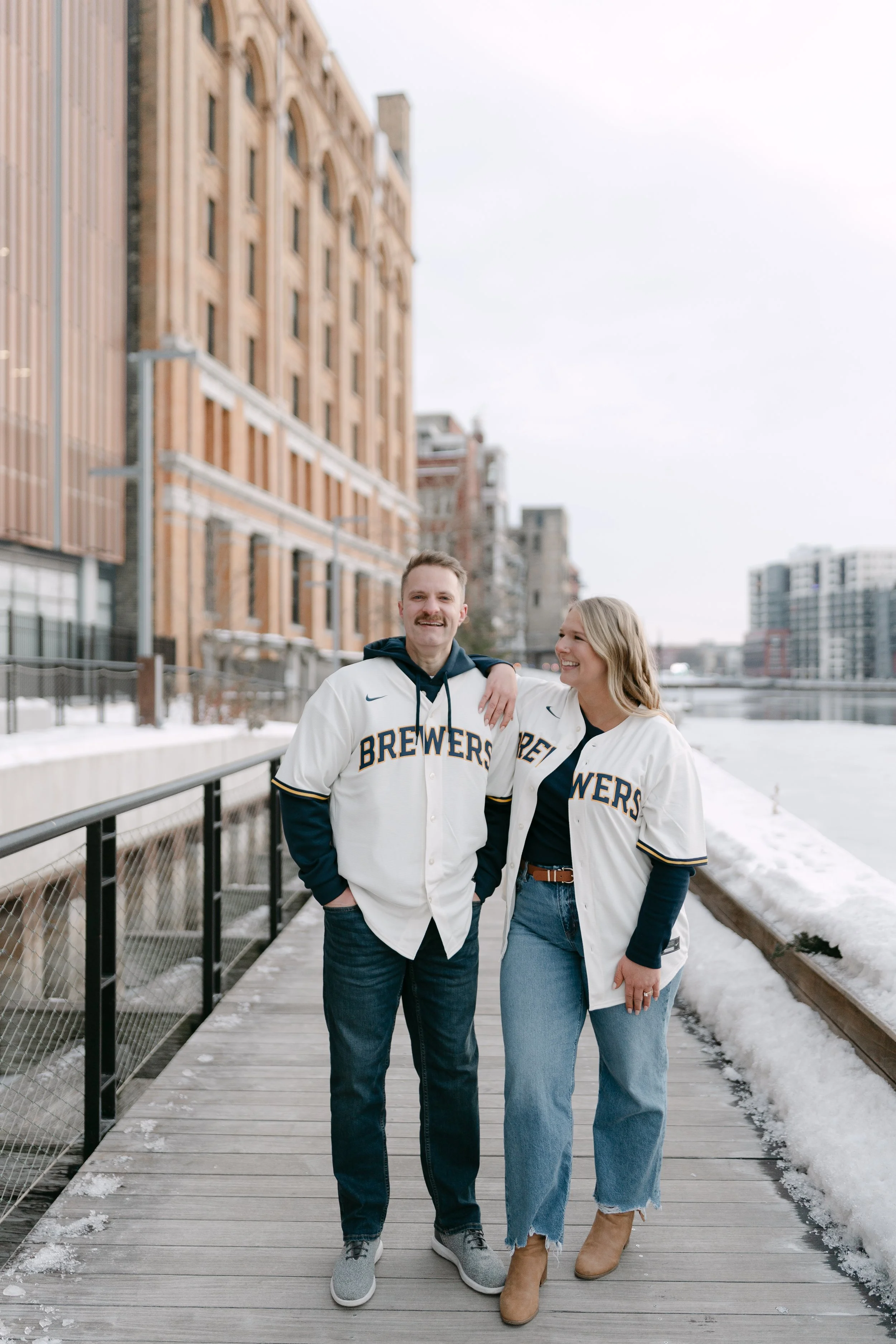 Engagement photos in Milwaukee’s Third Ward with couple wearing Brewers jerseys.