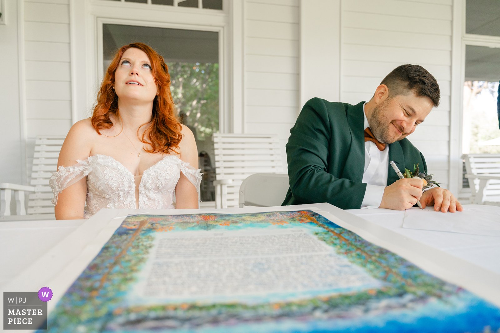 Bride and groom share a funny moment during the signing of their Katubah