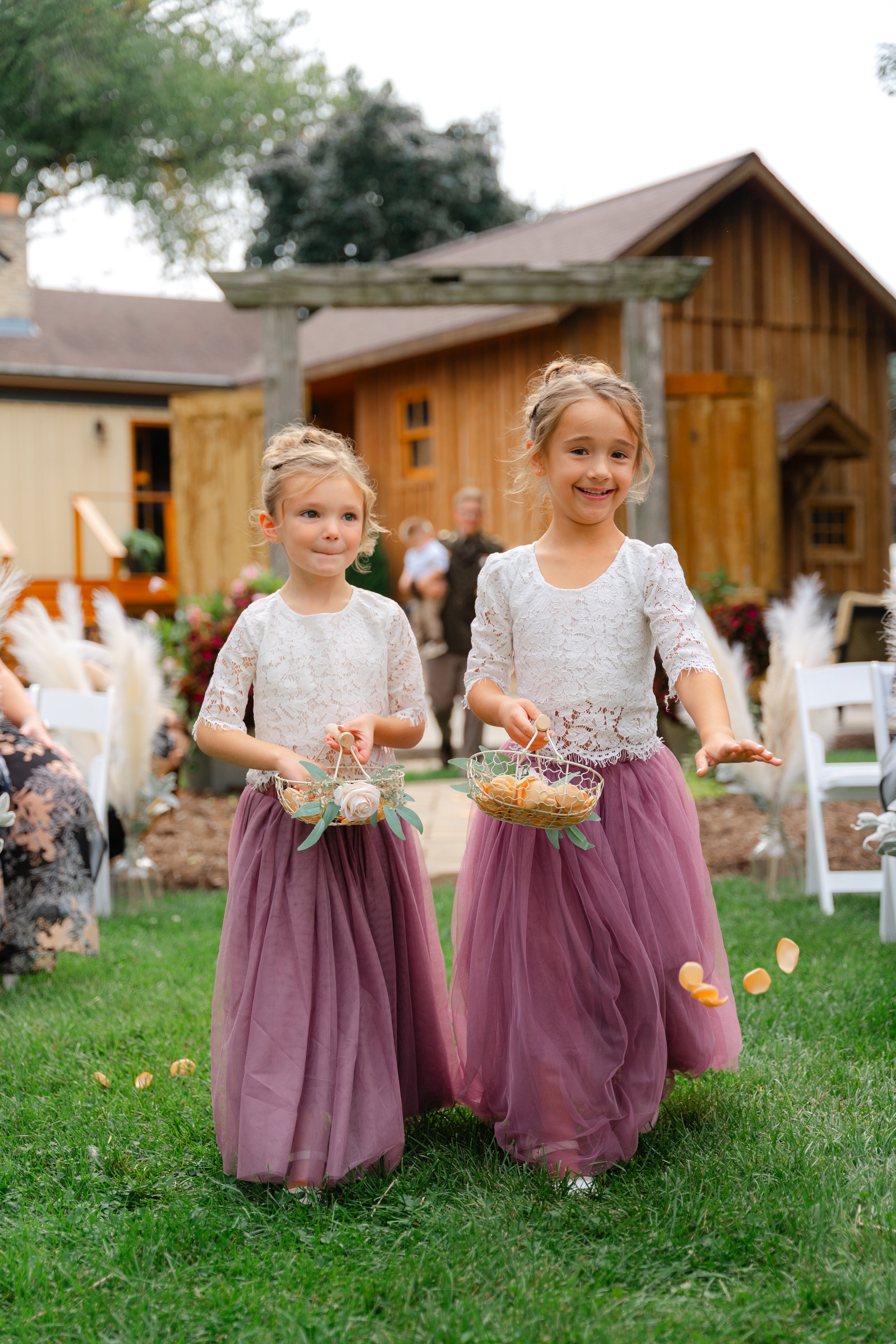 cute flower girls walking down the aisle during a ceremony in Richfield, Wisconsin