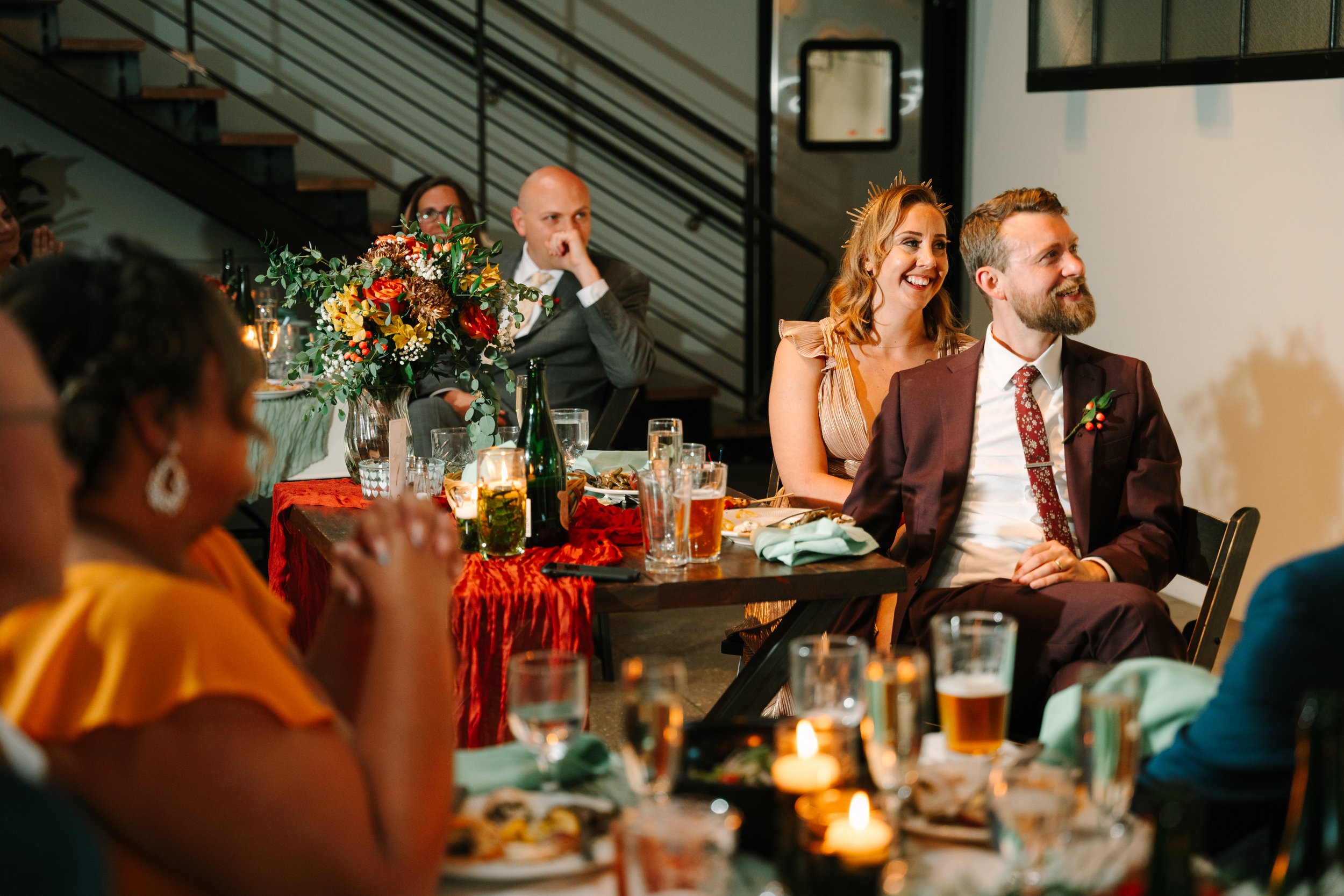 Couple listens to their friends and families speeches on their wedding day at The Tinsmith in Madison Wisconsin