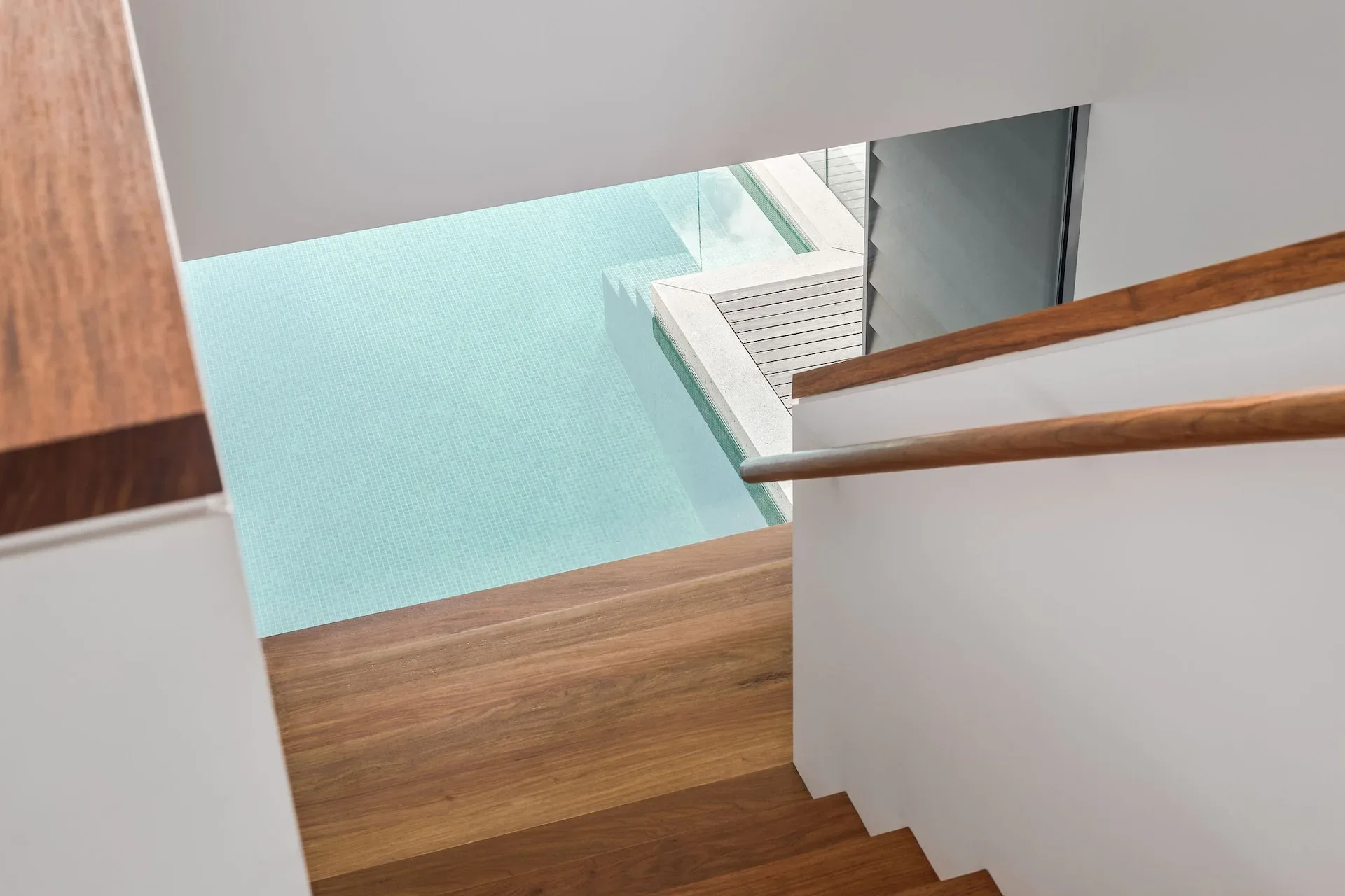 Stair void with natural light and pool view in modern home