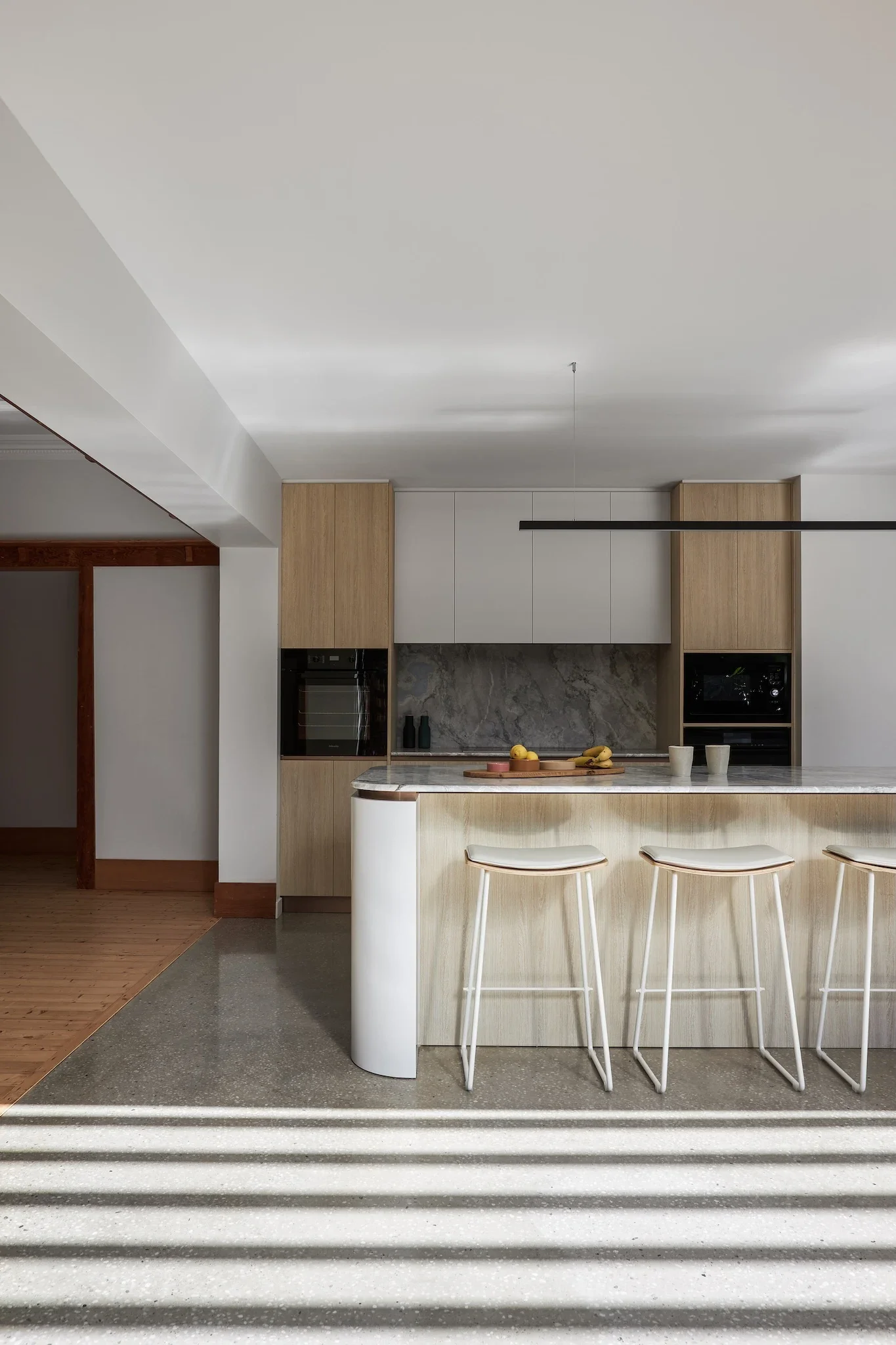 Contemporary kitchen renovation with curved island and natural materials, architect-designed home renovation by Ironbark Architecture