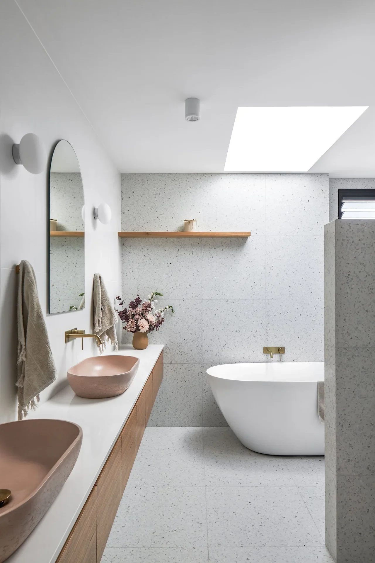 Refined bathroom vanity design in Northbridge with curved mirror and warm timber tones