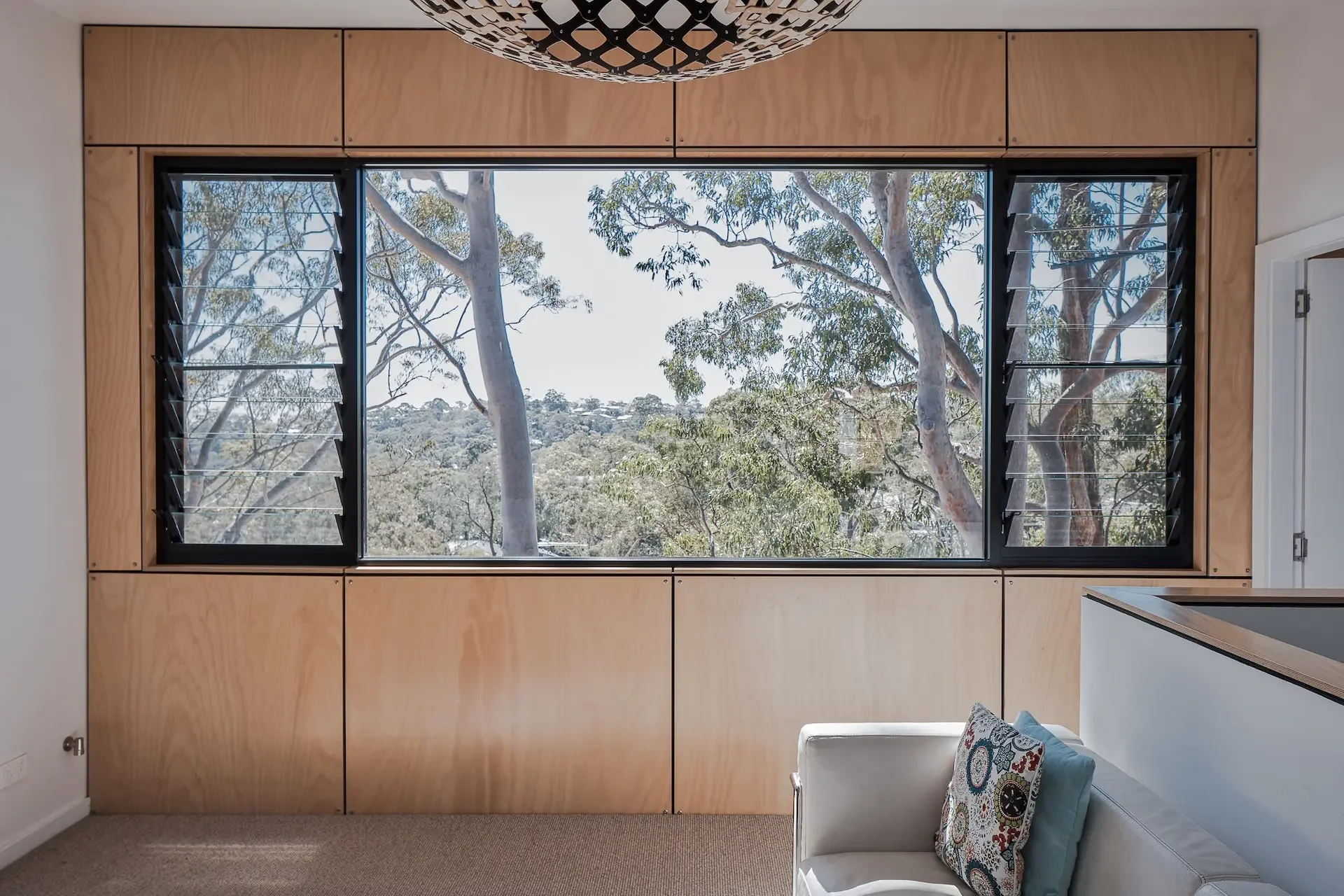Living space with large windows framing treetop views in a Gordon architect-designed home