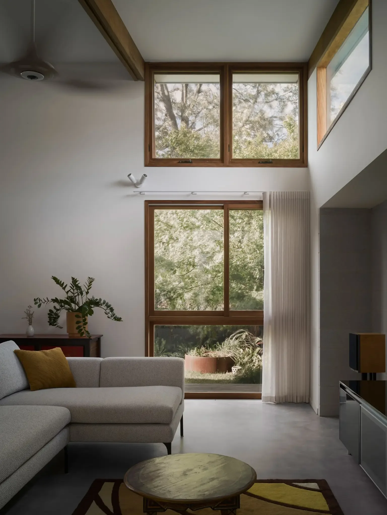 Light-filled living room in dual occupancy home with soft natural materials